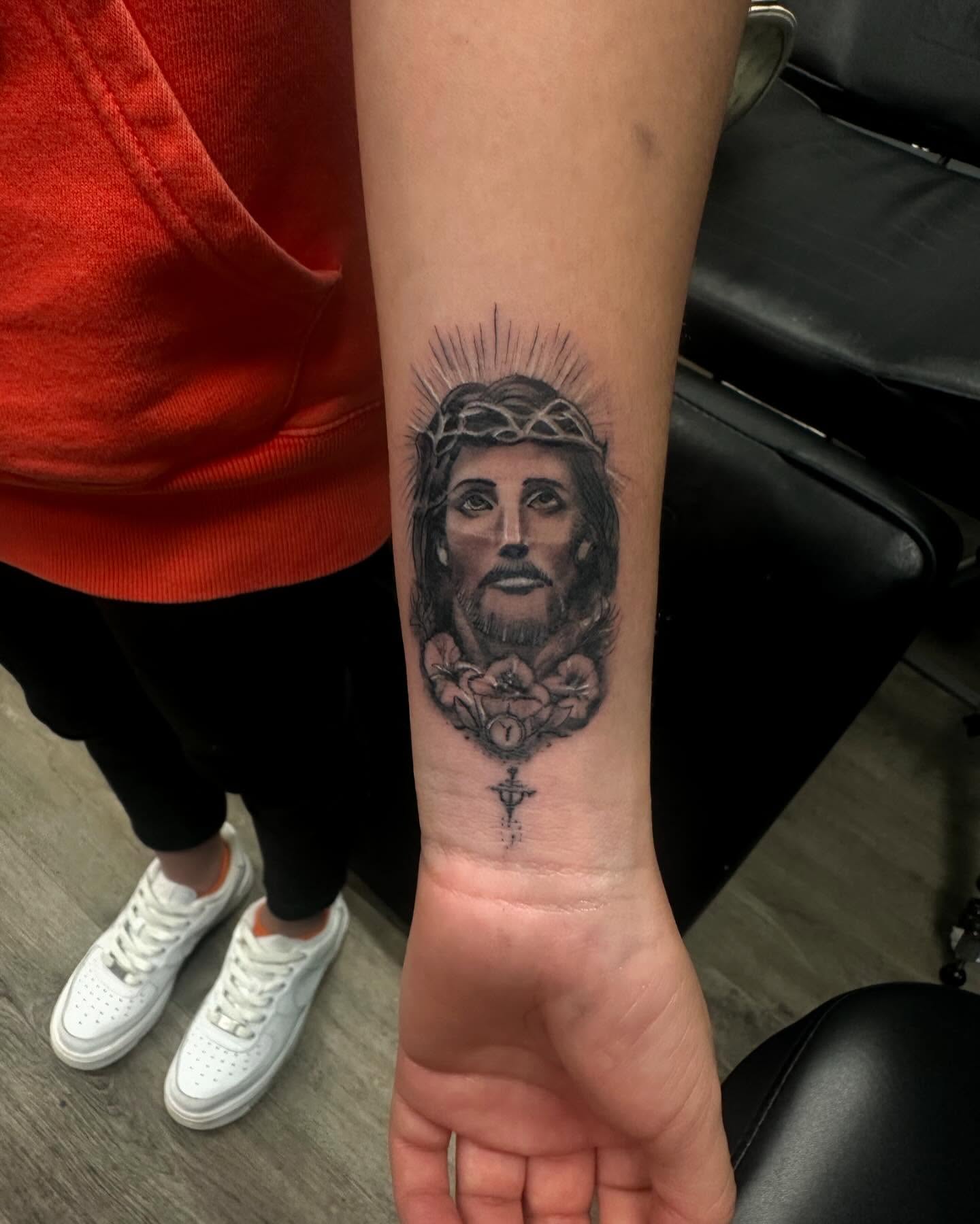 Religious figure black and grey tattoo on the forearm by Cyko Hernandez