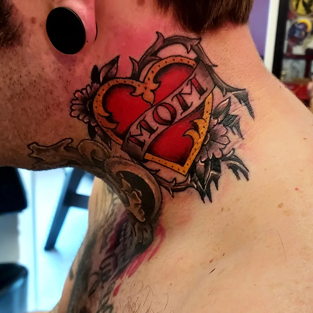 Heart with 'mom' American traditional tattoo on the neck by Dave Johnson, Billings, Montana