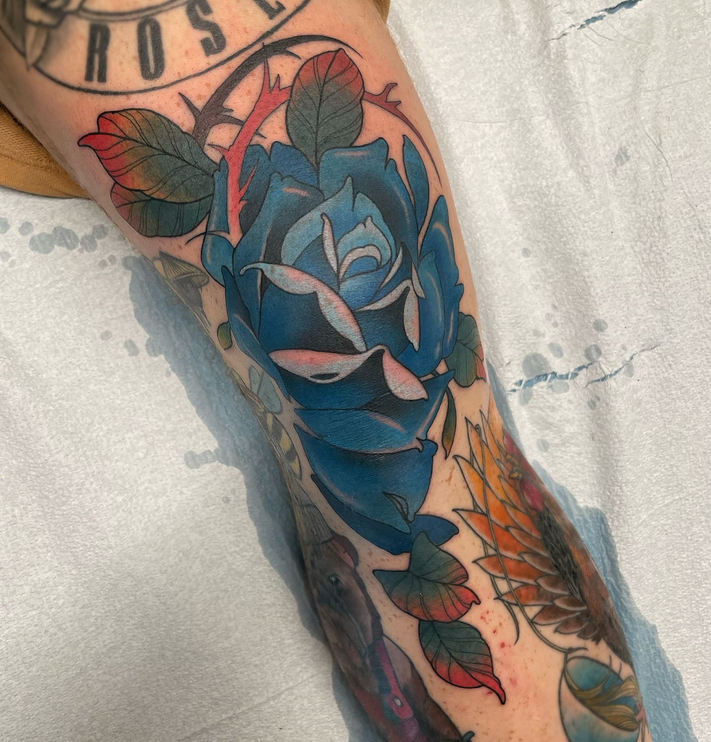 Blue rose American traditional tattoo on the forearm by Anne Cornelson