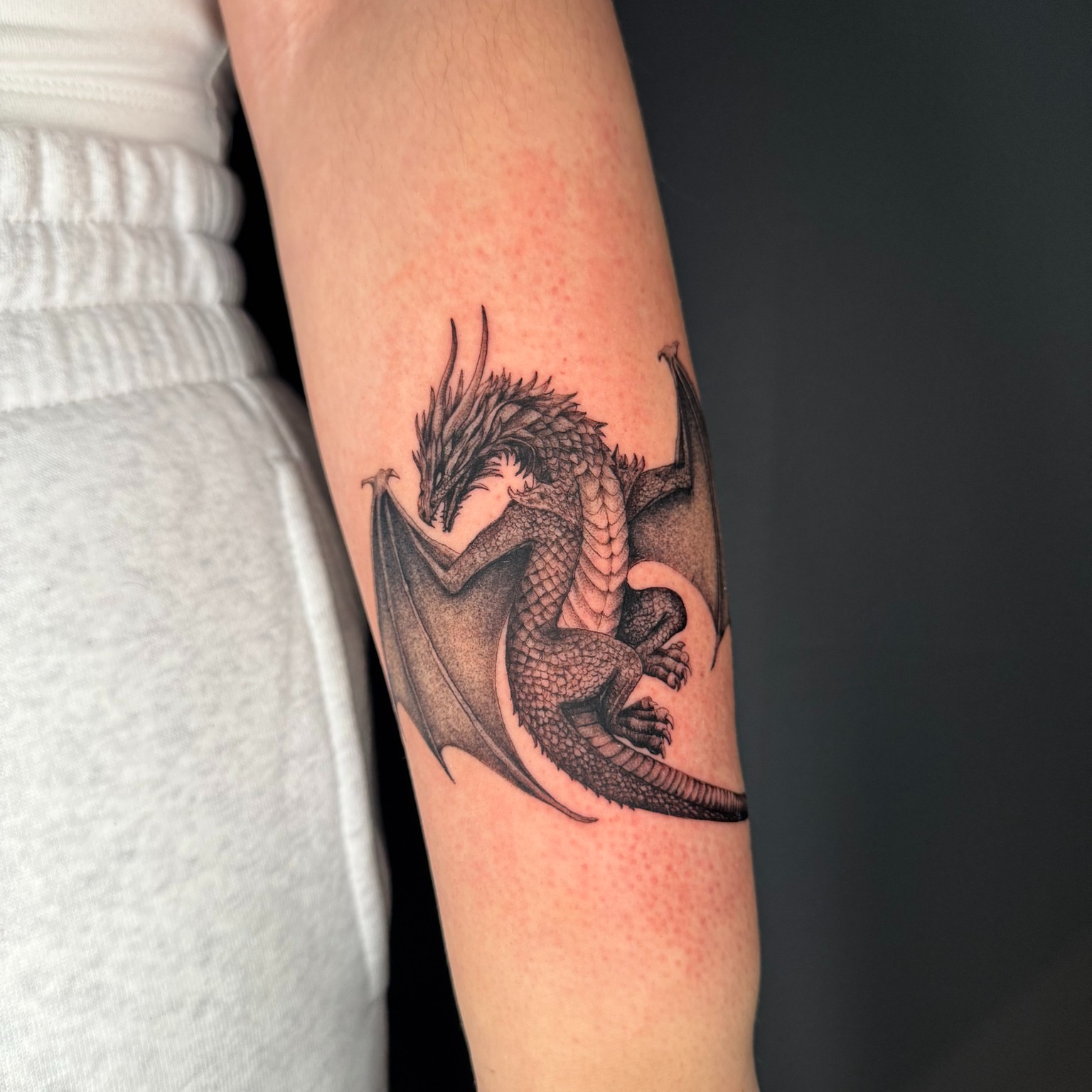Dragon black and grey tattoo on the forearm by Ninna