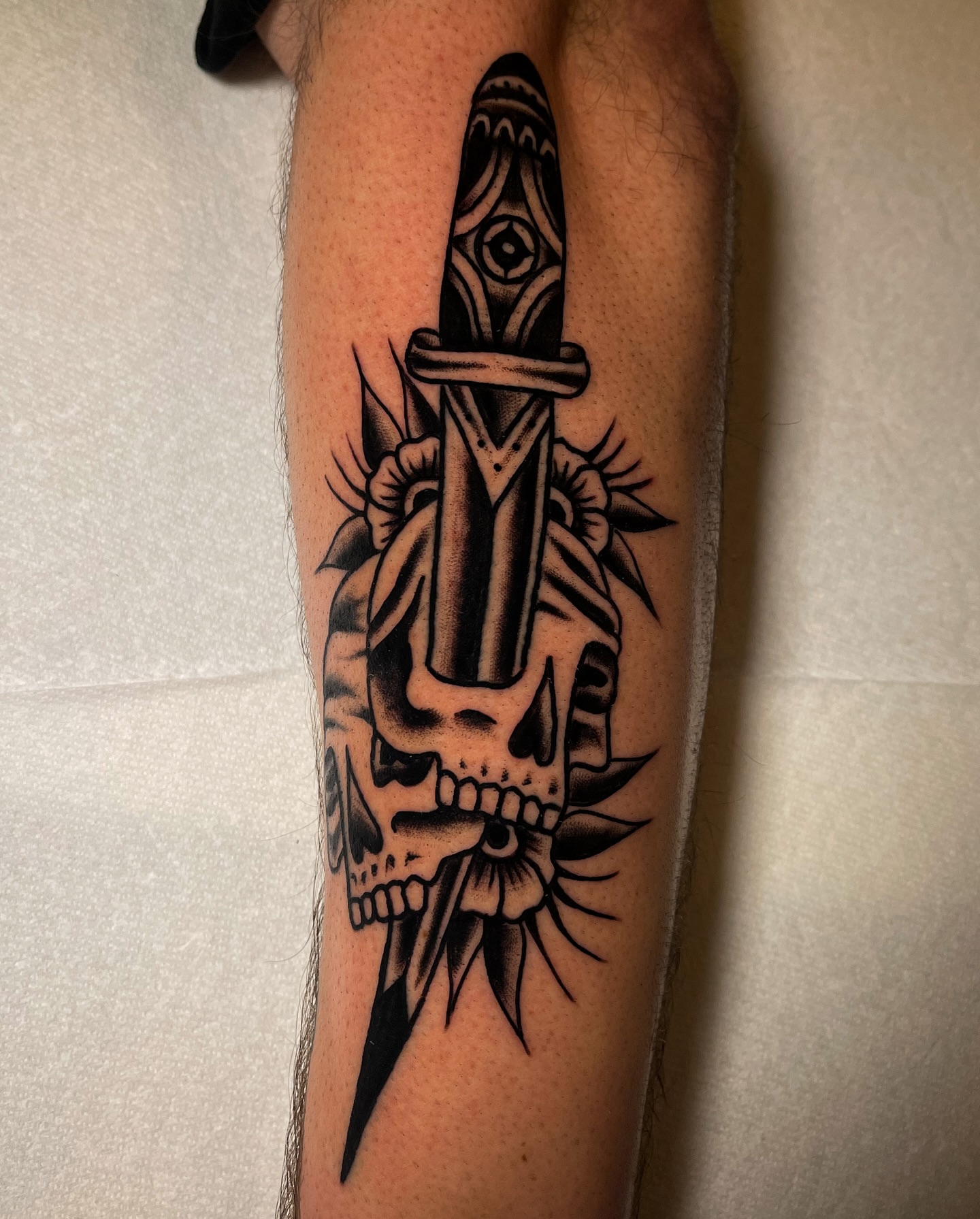 Skull with dagger geometric tattoo on the forearm by Miguel Henrik