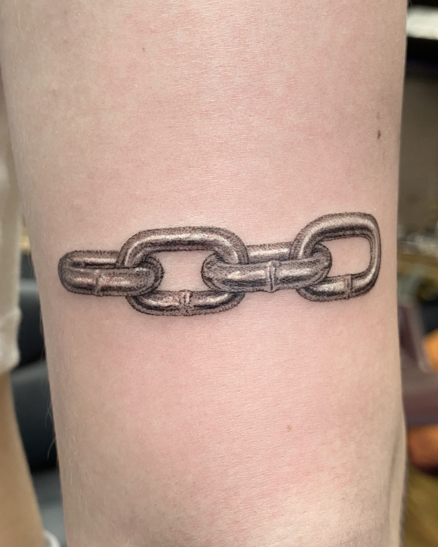 Chain black and grey tattoo on the forearm by Dan Sprague