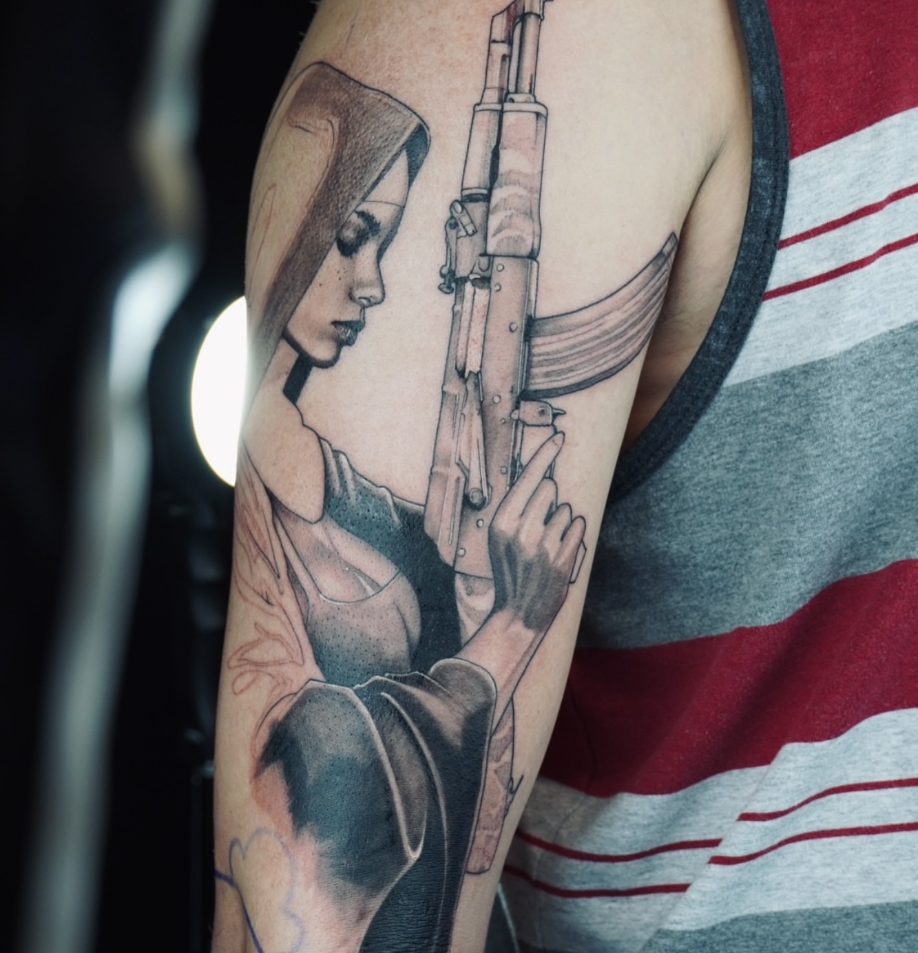 Woman with gun realism tattoo on the forearm by Apologies tattoo studios.