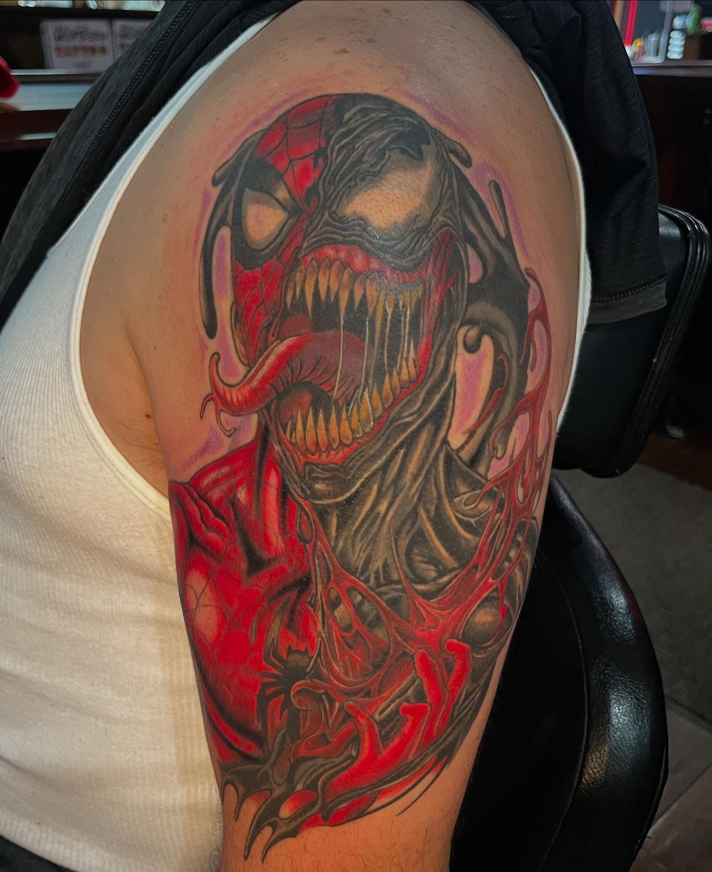 Venom dark realism tattoo on the shoulder by Kenny Buck
