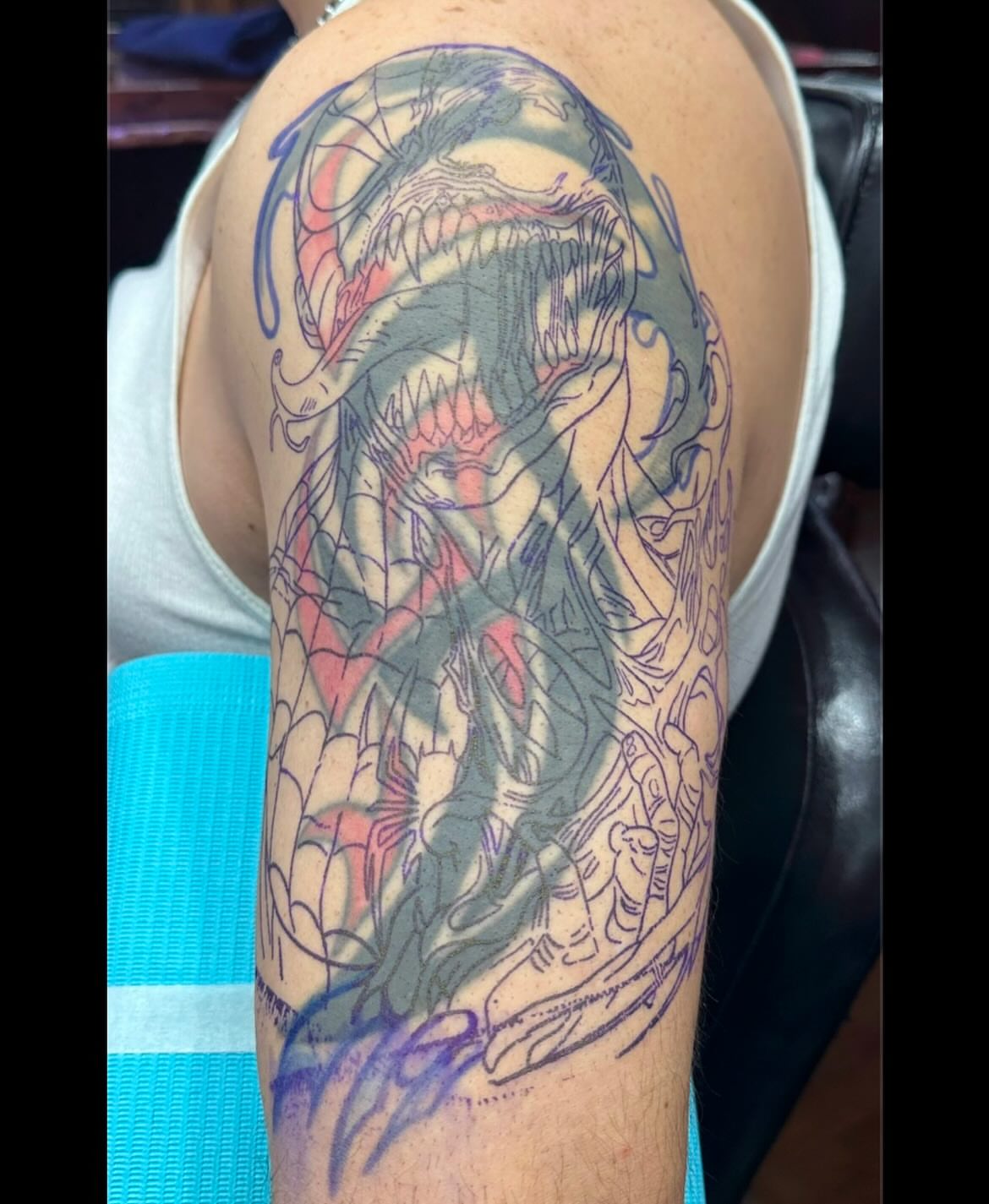 Venom new school tattoo on the upper arm by Kenny Buck
