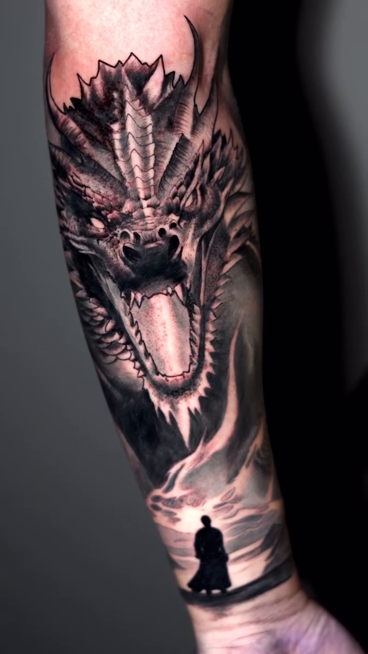 Dragon head with a silhouette figure realism tattoo by Luis Arenas