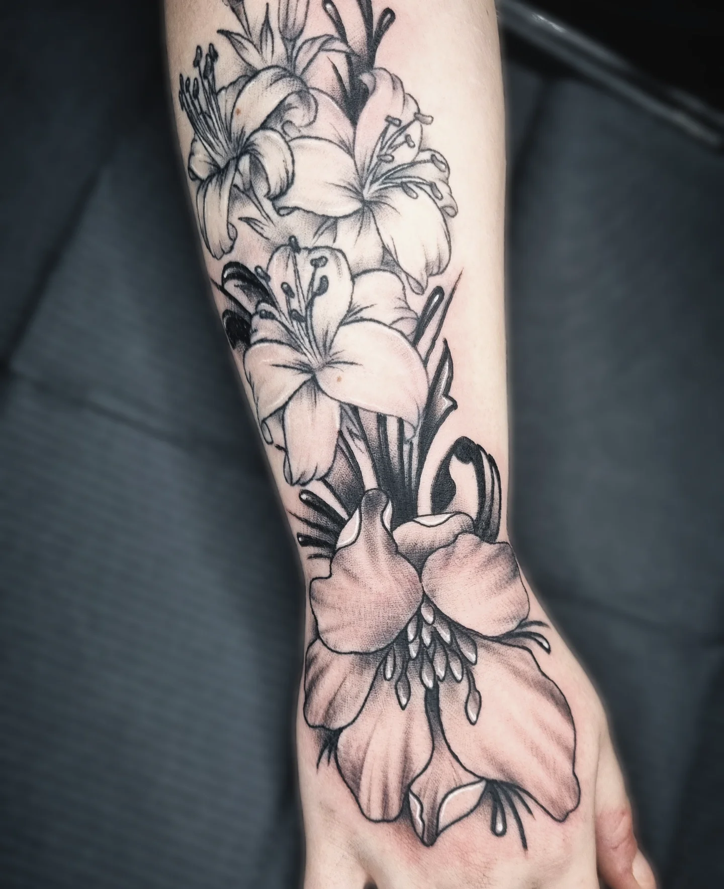Lilies black and grey tattoo on the forearm by AntiheroTattoo
