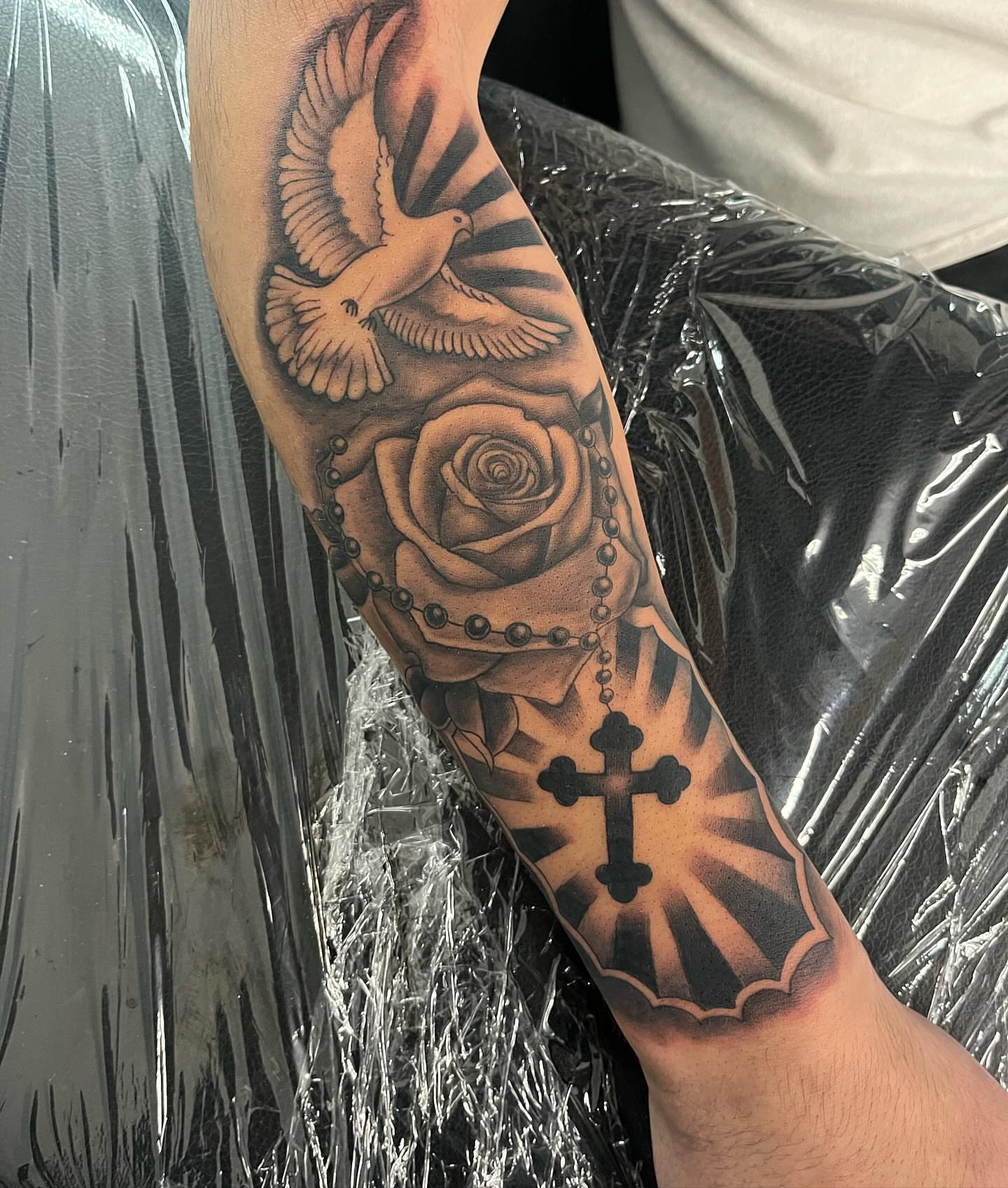 Rose and cross realism tattoo on the forearm by Detroit Tattoo Artist