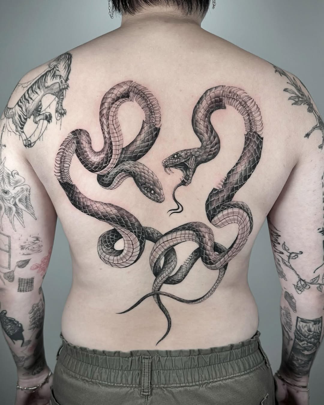 Two intertwined snakes American traditional tattoo on the back by eugene k 🌈, San Francisco, California