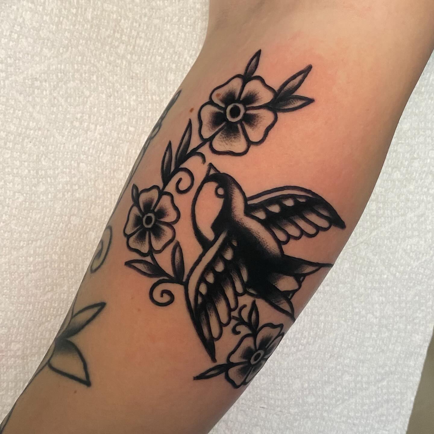 Bird and flowers American traditional tattoo on the forearm by Shana