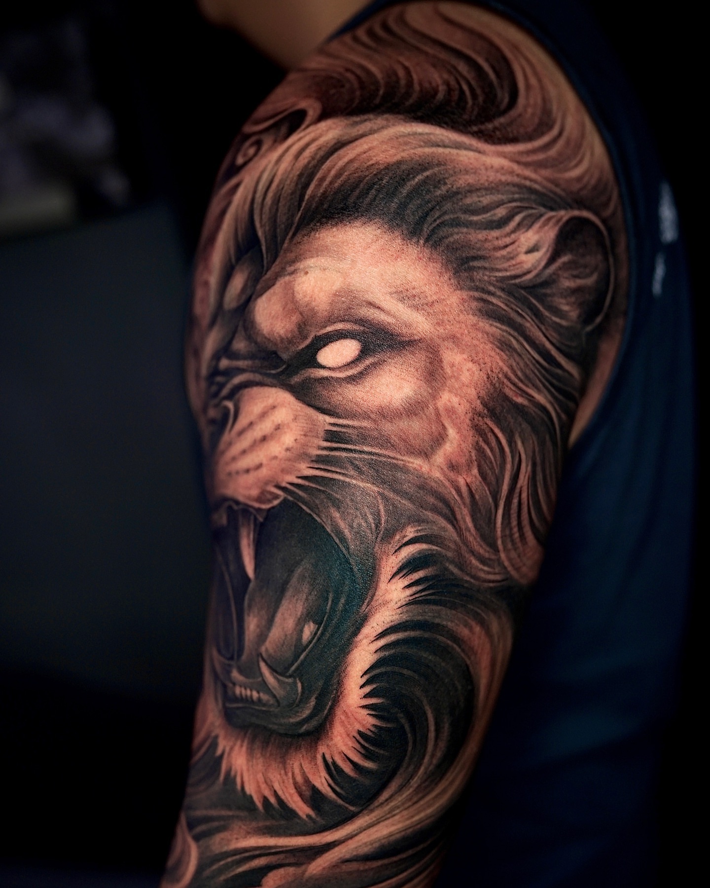 Lion realism tattoo on the upper arm by Thien Phan