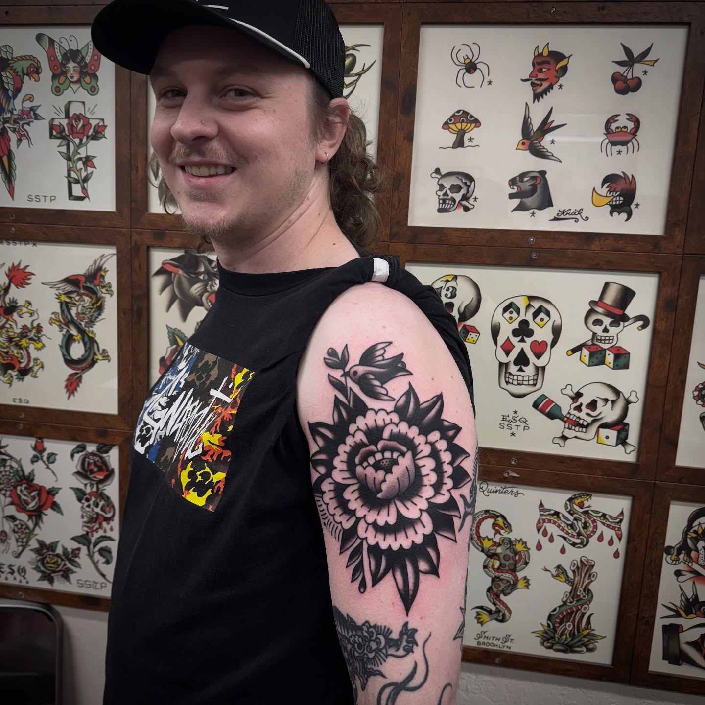 Flower American traditional tattoo on the upper arm by Rogelio Robles