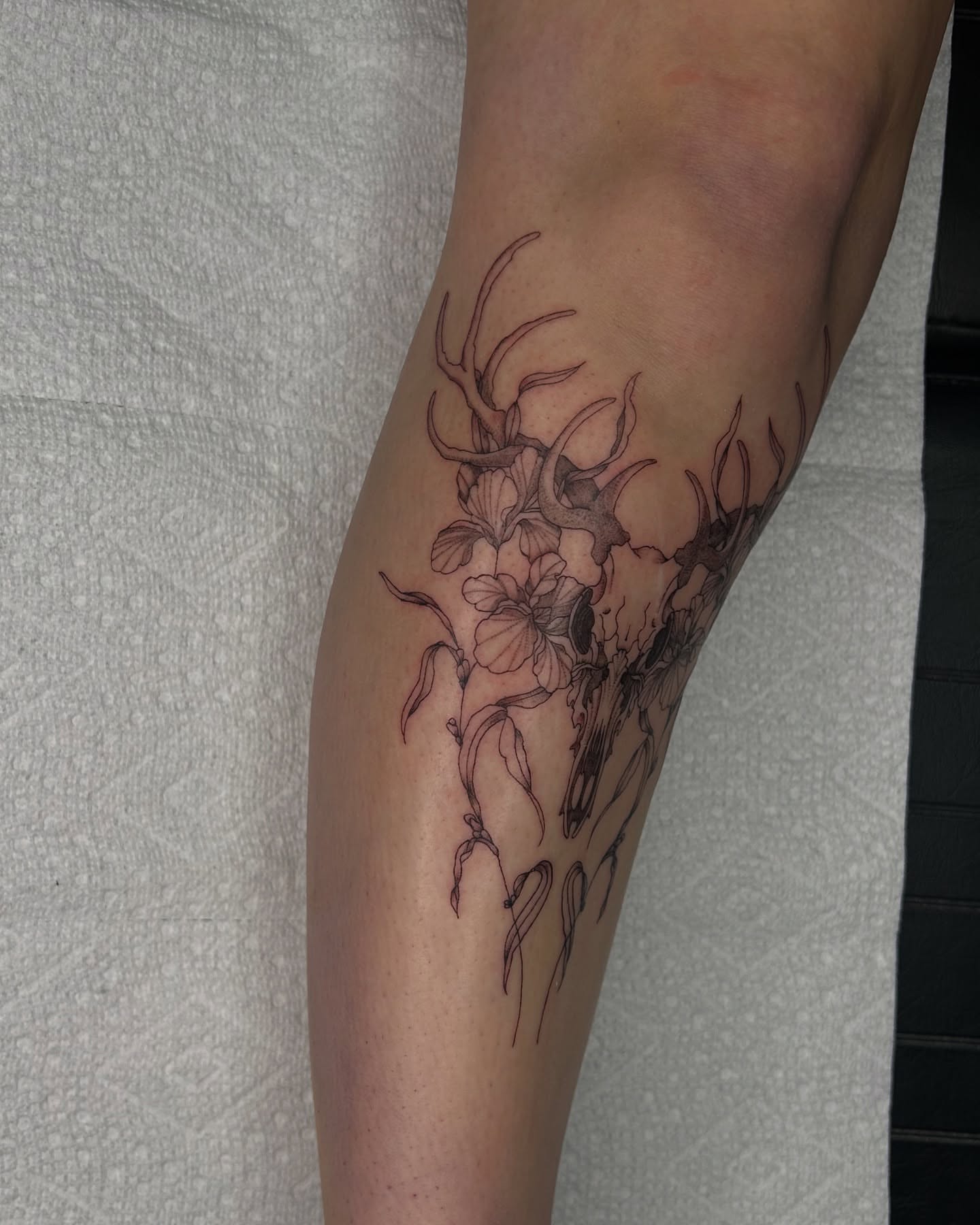 Deer and flowers realism tattoo on the forearm by Kennedy Ramey