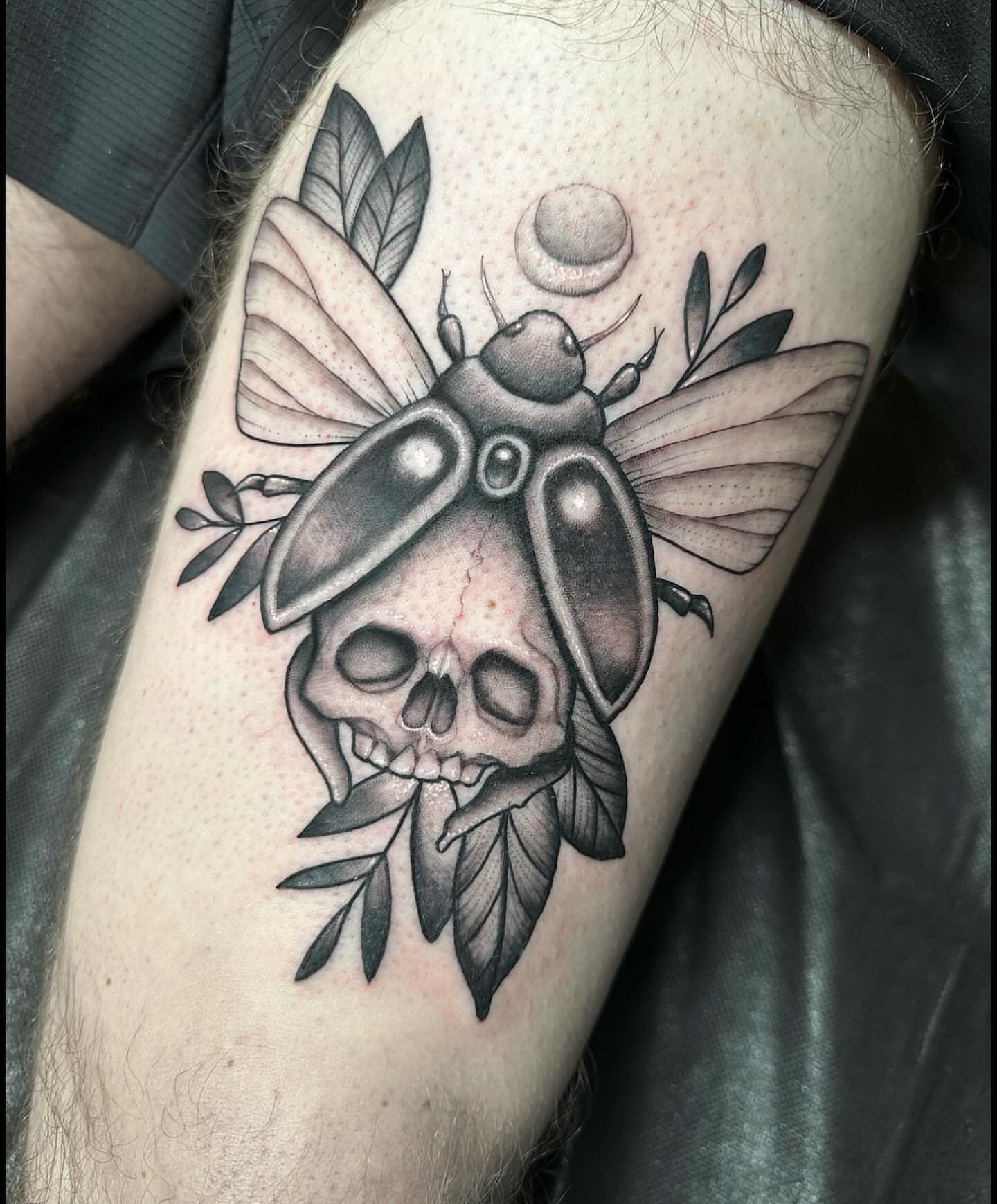 Skull and beetle black and grey tattoo on the forearm by Lawrence Edwards