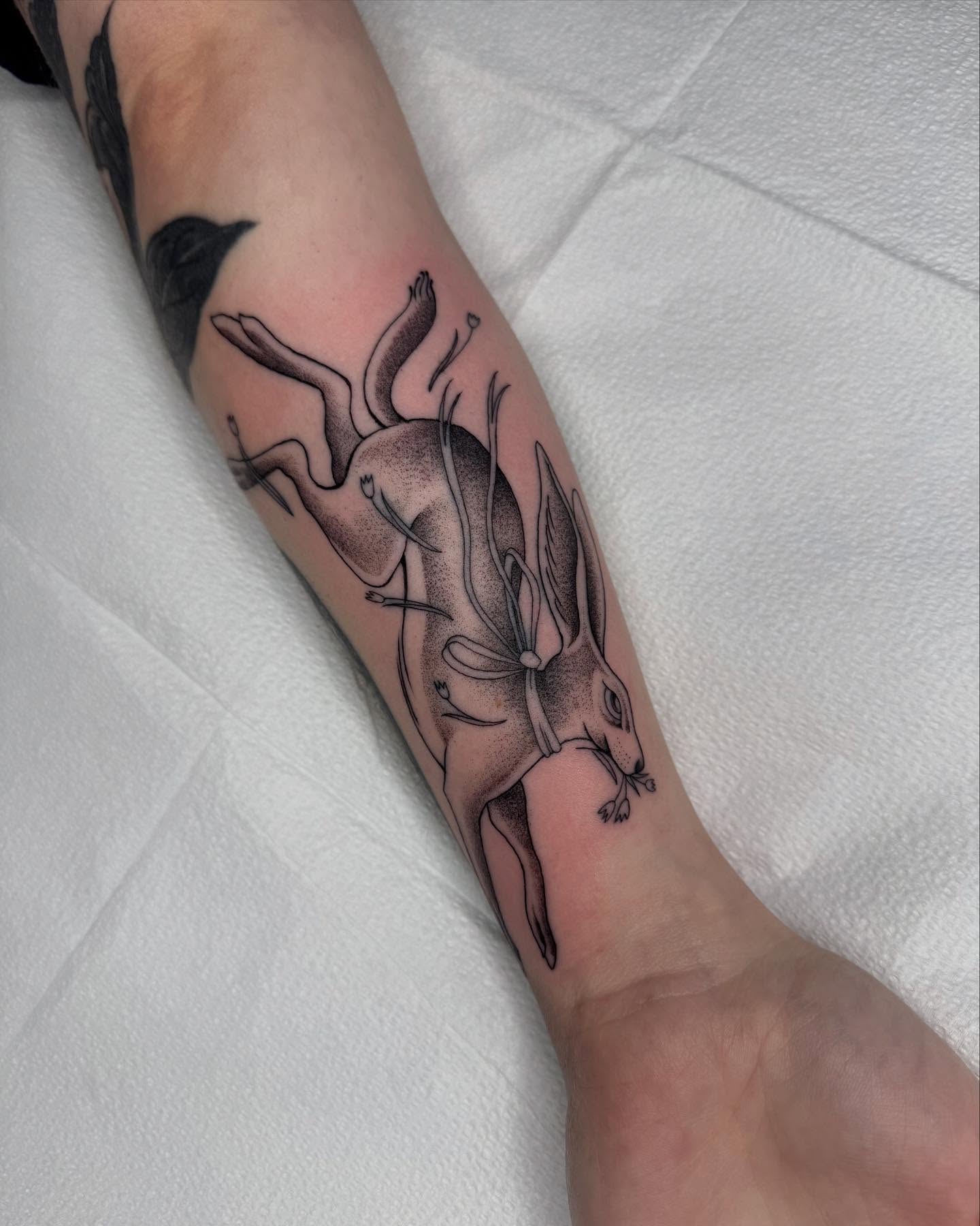 Hare and flowers dotwork tattoo on the forearm by Finley Jordan