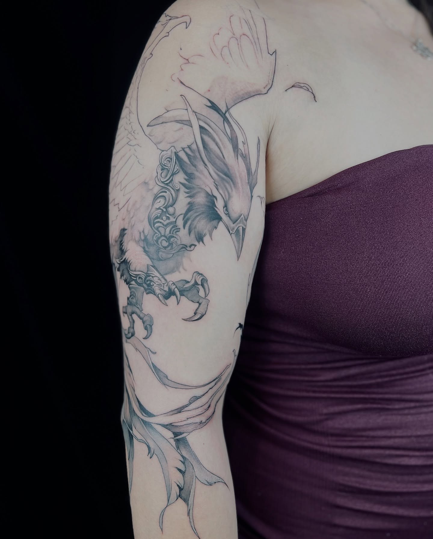 Phoenix black and grey tattoo on the upper arm by Apologies tattoo studios.