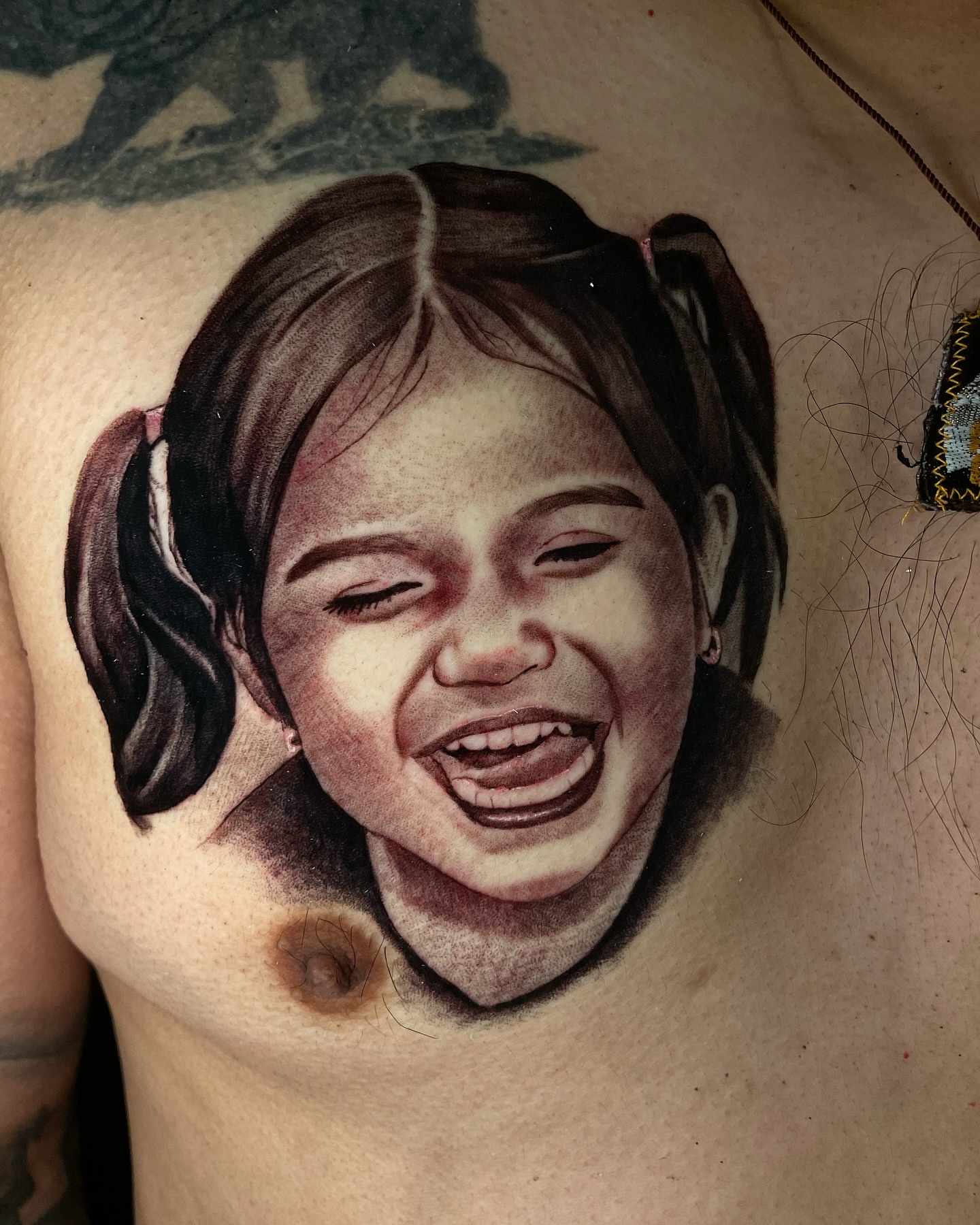 Child's face realism tattoo on the chest by Vic