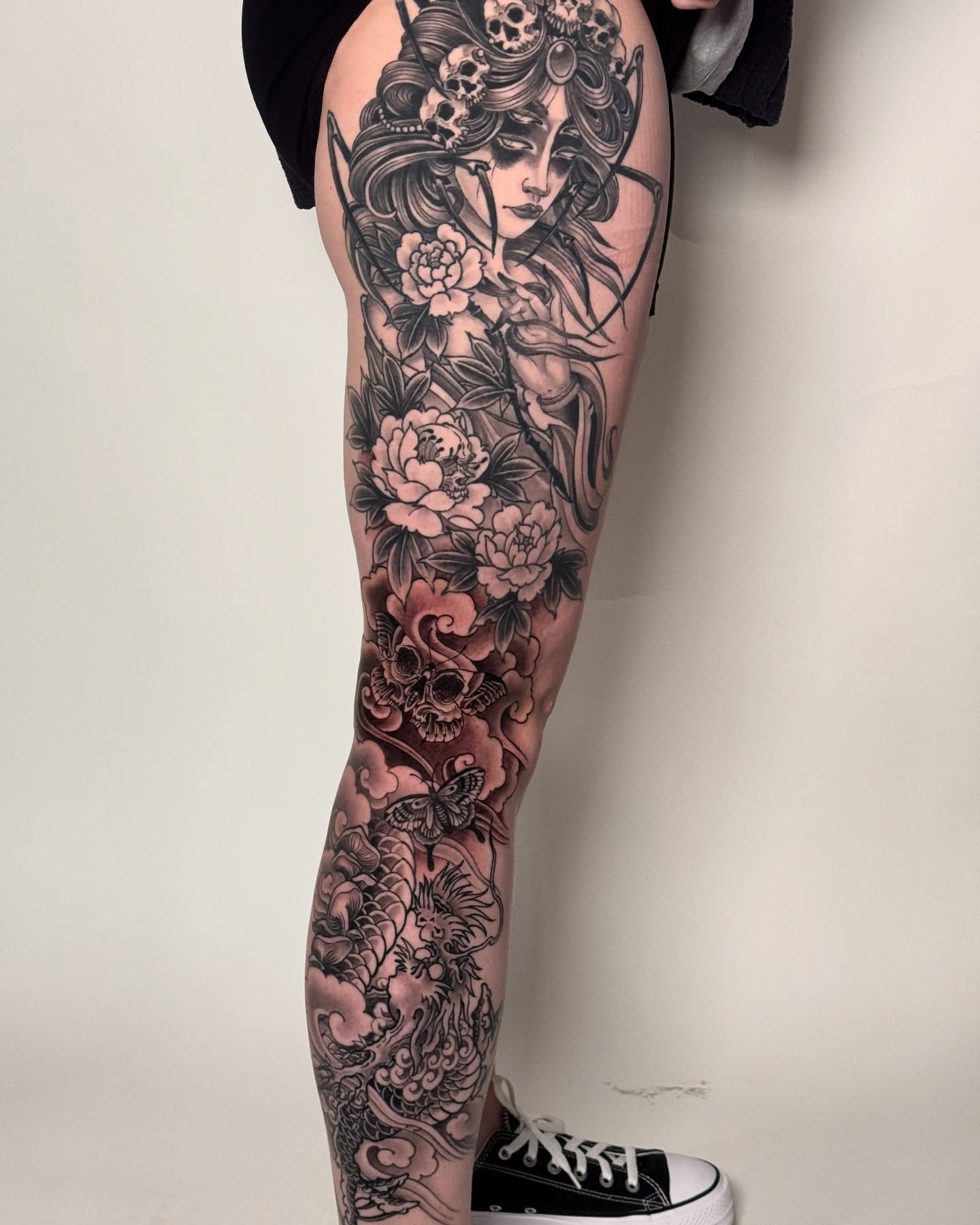Woman with flowers and skulls japanese irezumi tattoo on the leg by Tattooer by Trade Wannabe Artist at Heart
