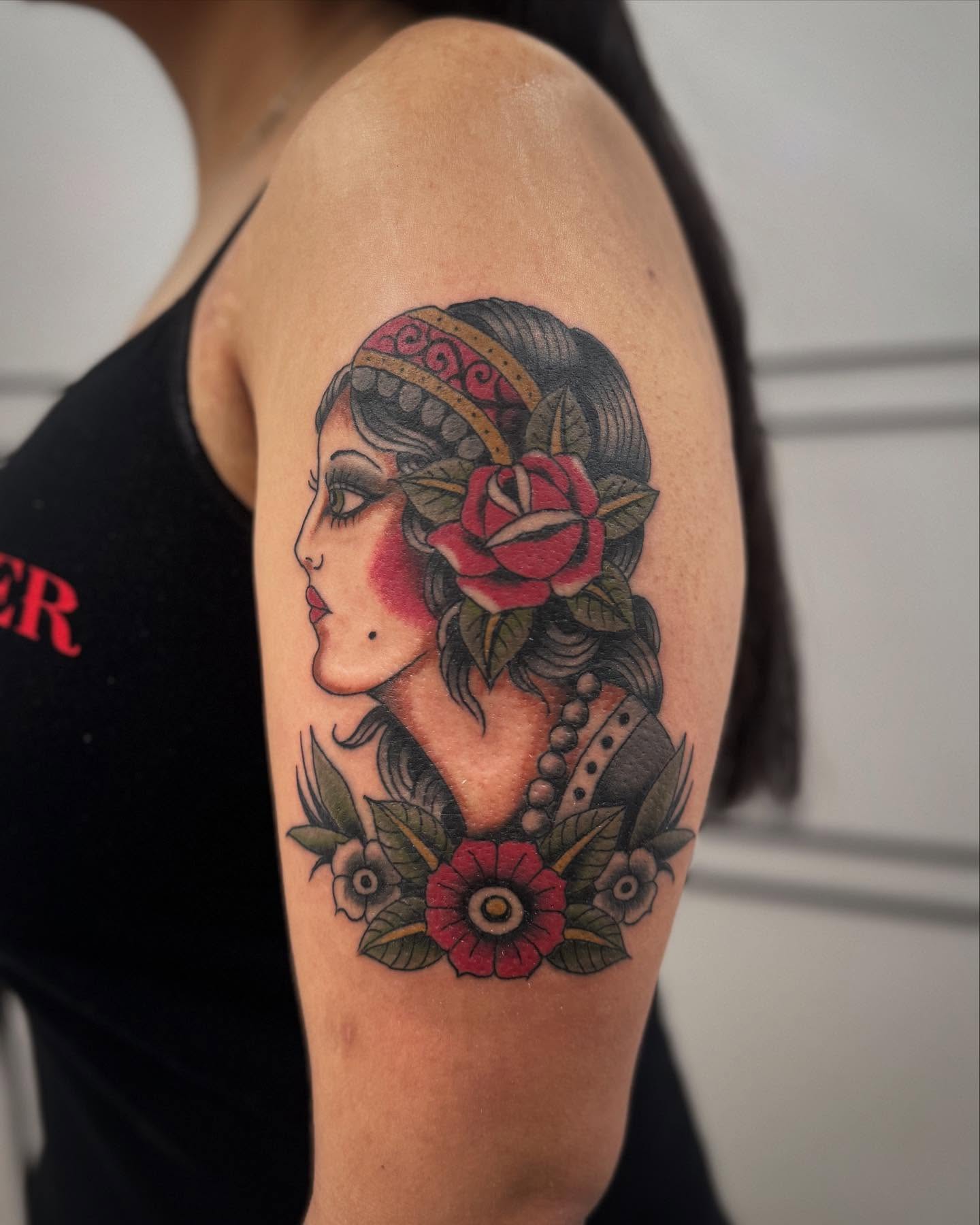 Woman with floral crown American traditional tattoo on the shoulder by Micah Norman, San Francisco, California