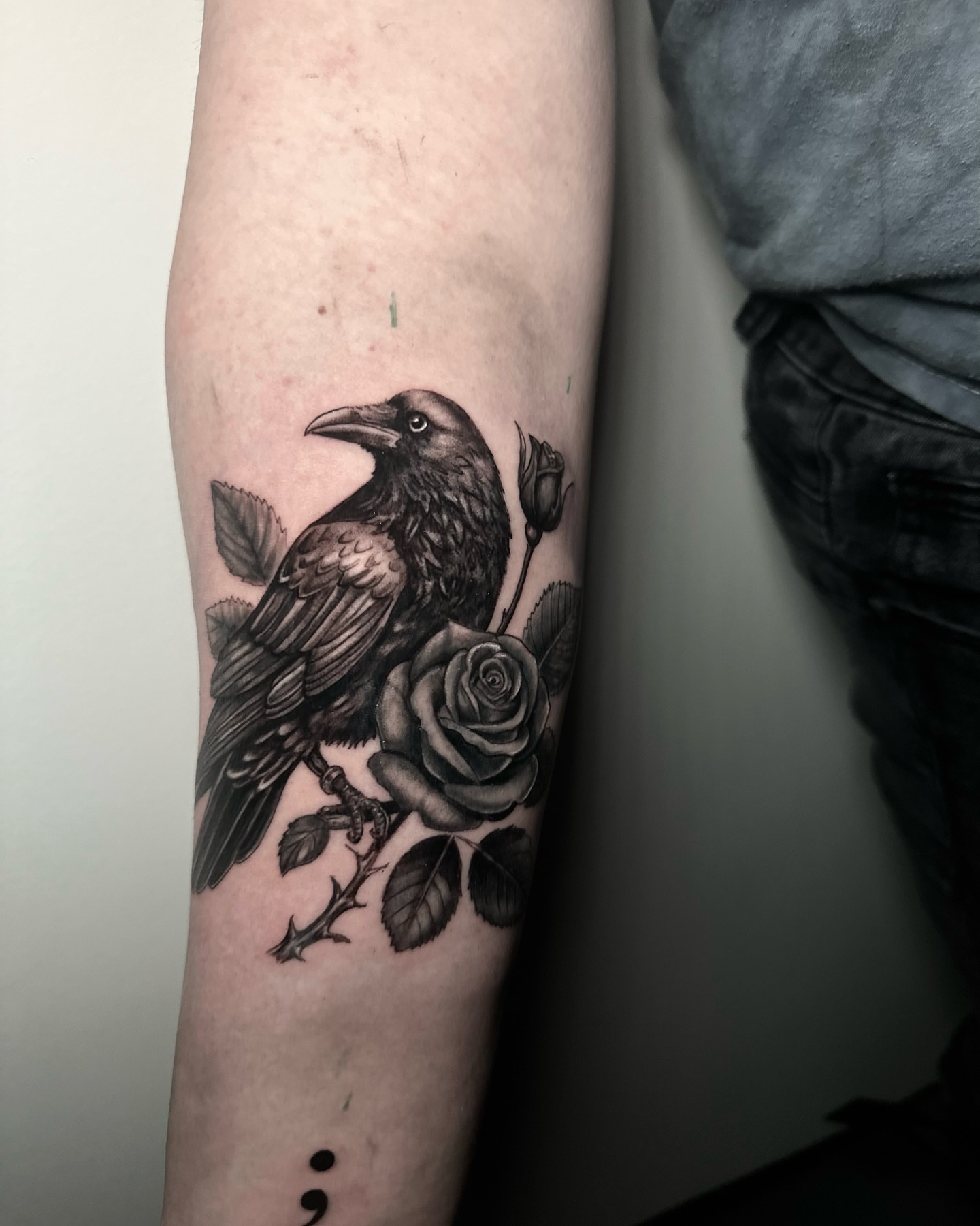 Crow and rose realism tattoo on the forearm by Héctor Agudelo