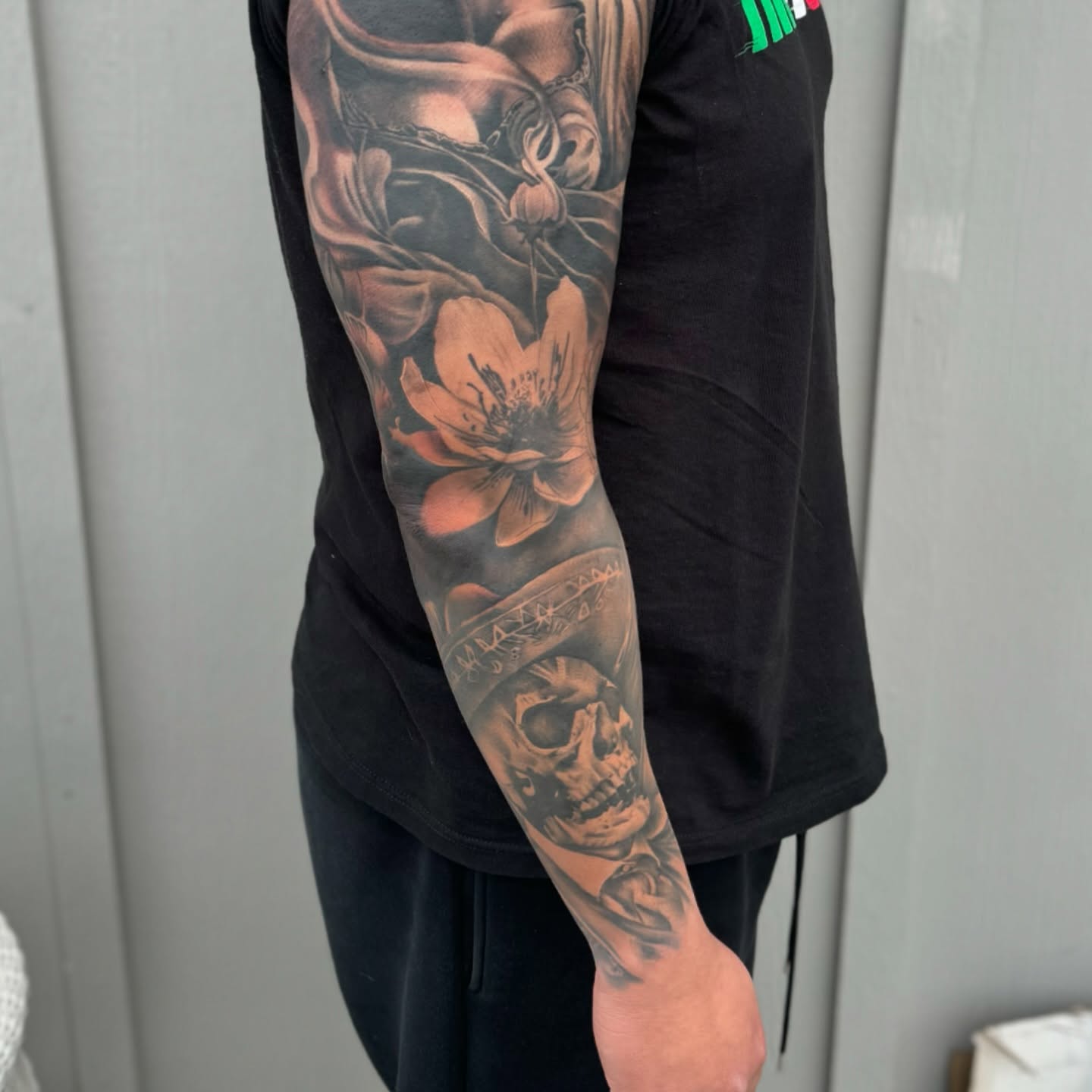 Skull and flowers realism tattoo on the forearm by Angel Pineda-Rodriguez