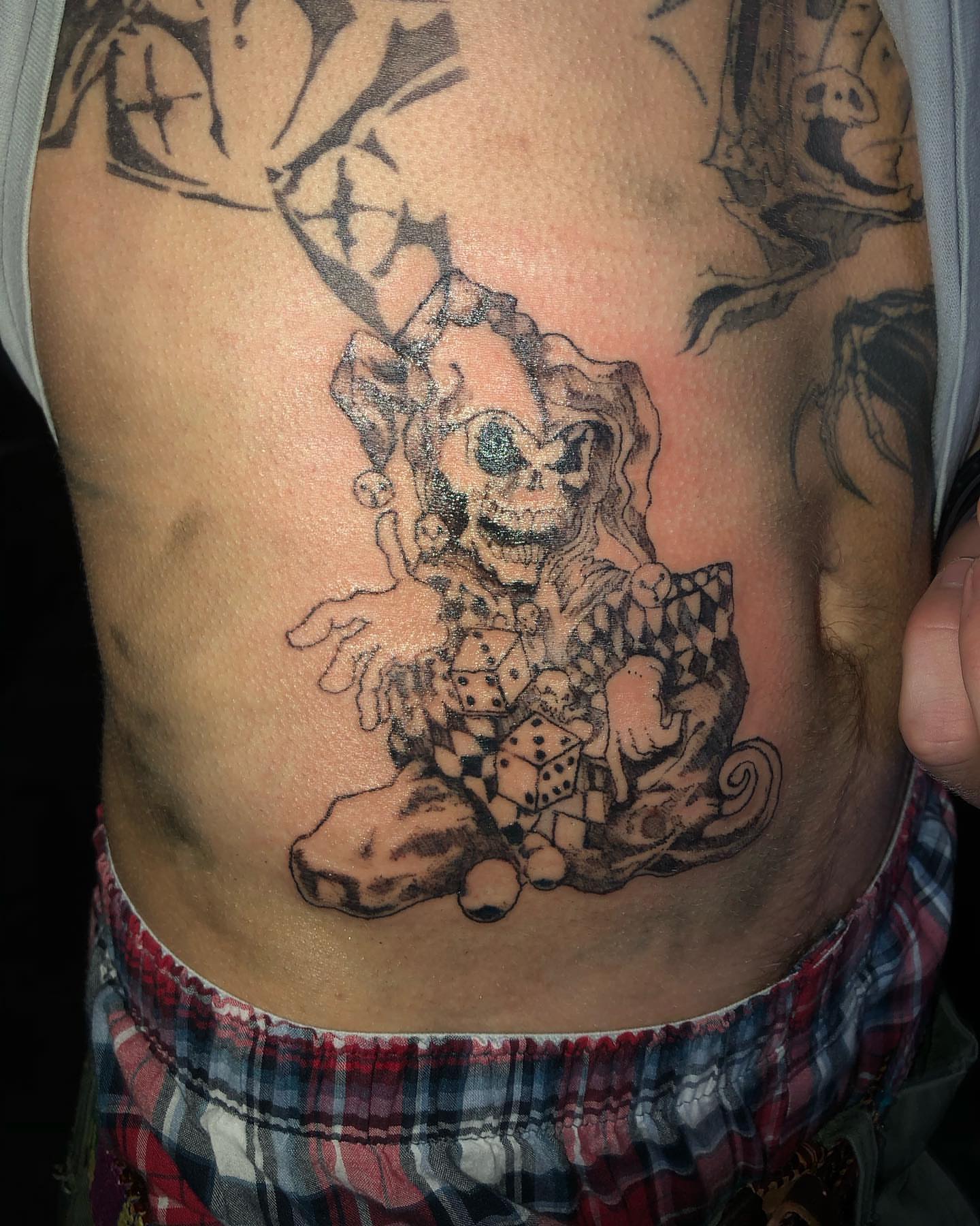 Joker black and grey tattoo on the ribs by @emotionalthugtattoo