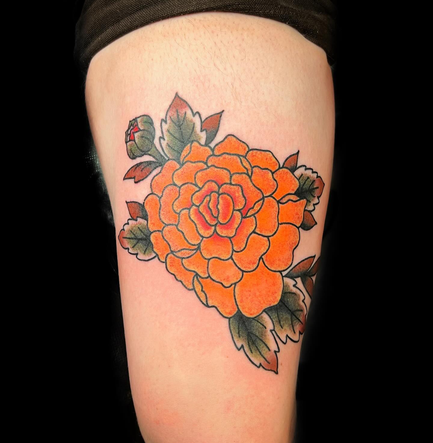 Orange flower American traditional tattoo on the thigh by @sloanxkettering