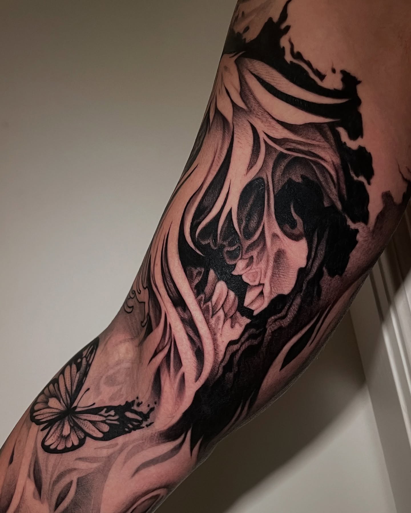 Skull and butterfly realism tattoo on the forearm by Michelle Carlton