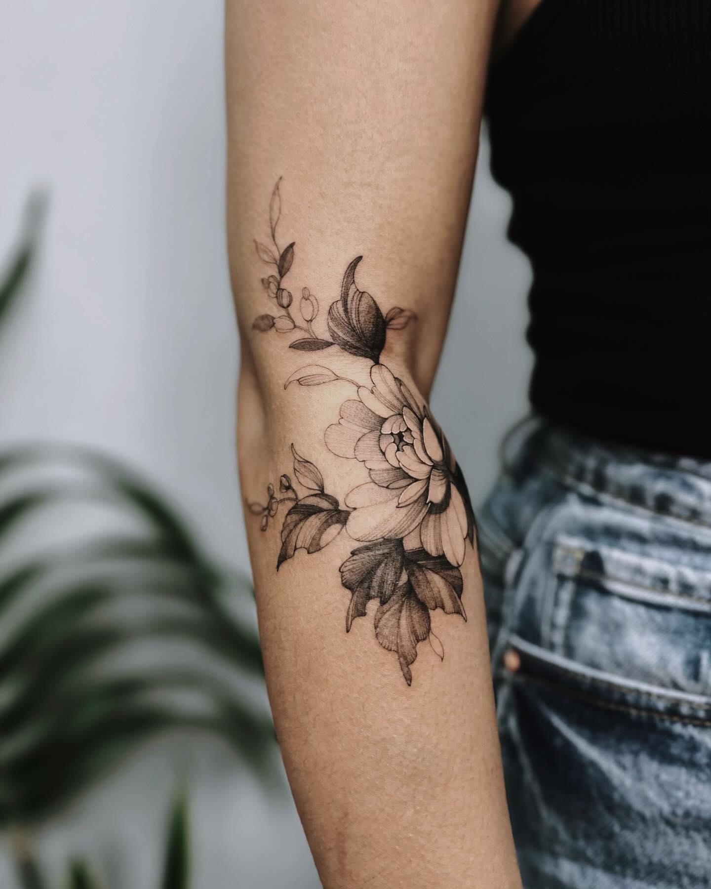 Floral arrangement black and grey tattoo on the forearm by Angel