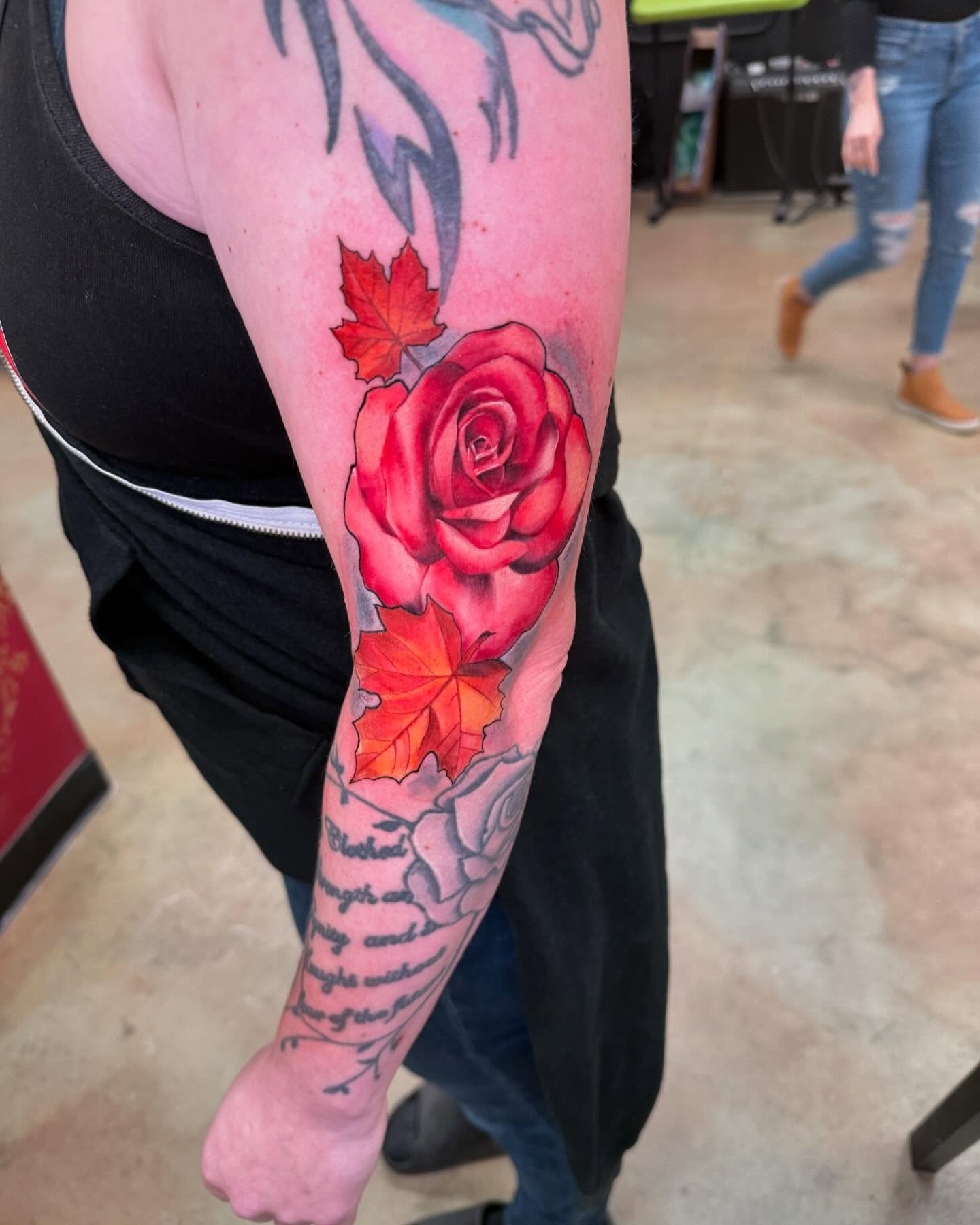Red rose and maple leaves realism tattoo on the forearm by Shawn Cook
