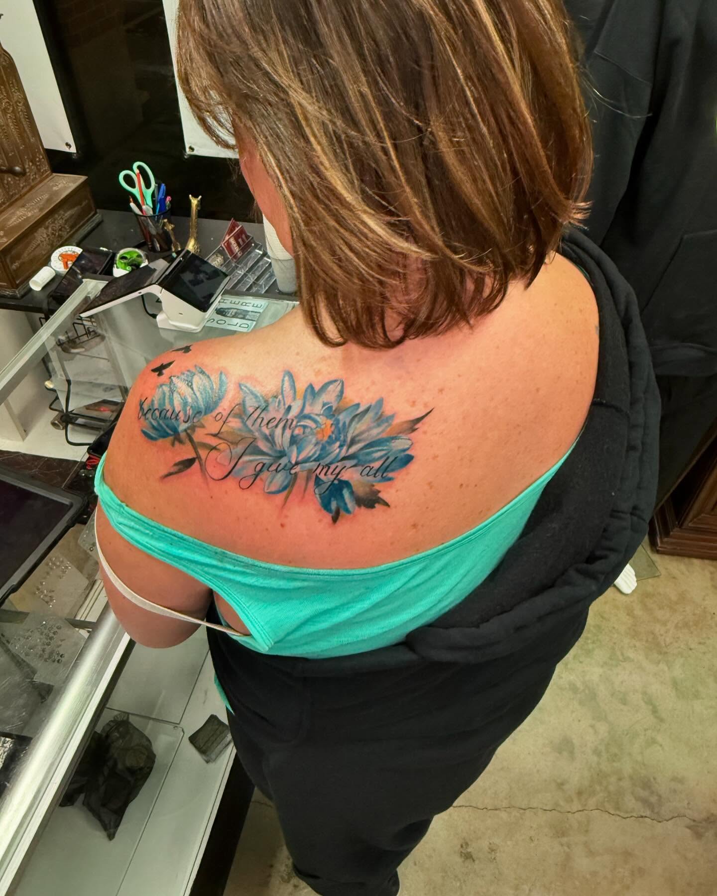 Blue flowers watercolor tattoo on the shoulder by Shawn Cook