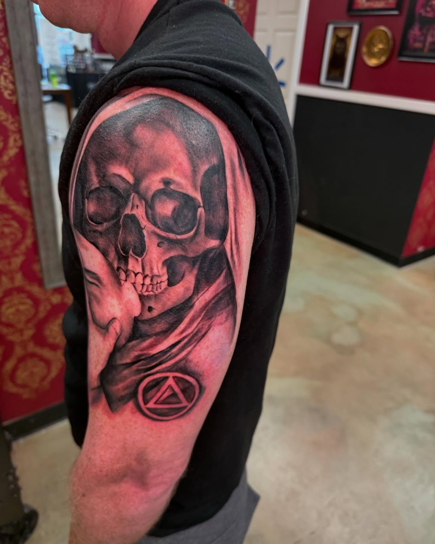 Skull with hand realism tattoo on the shoulder by Shawn Cook