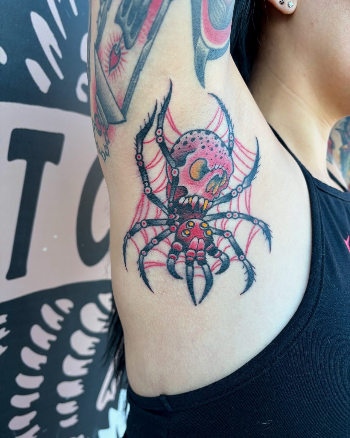 Spider trash polka tattoo on the upper arm by Kevin Starai