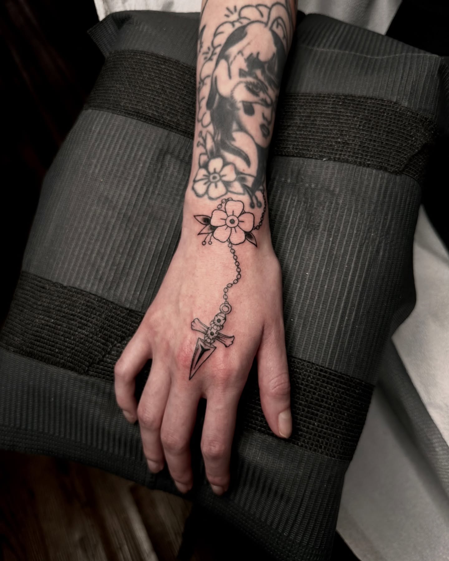 Flower and dagger black and grey tattoo on the hand by Emersyn DeLuna