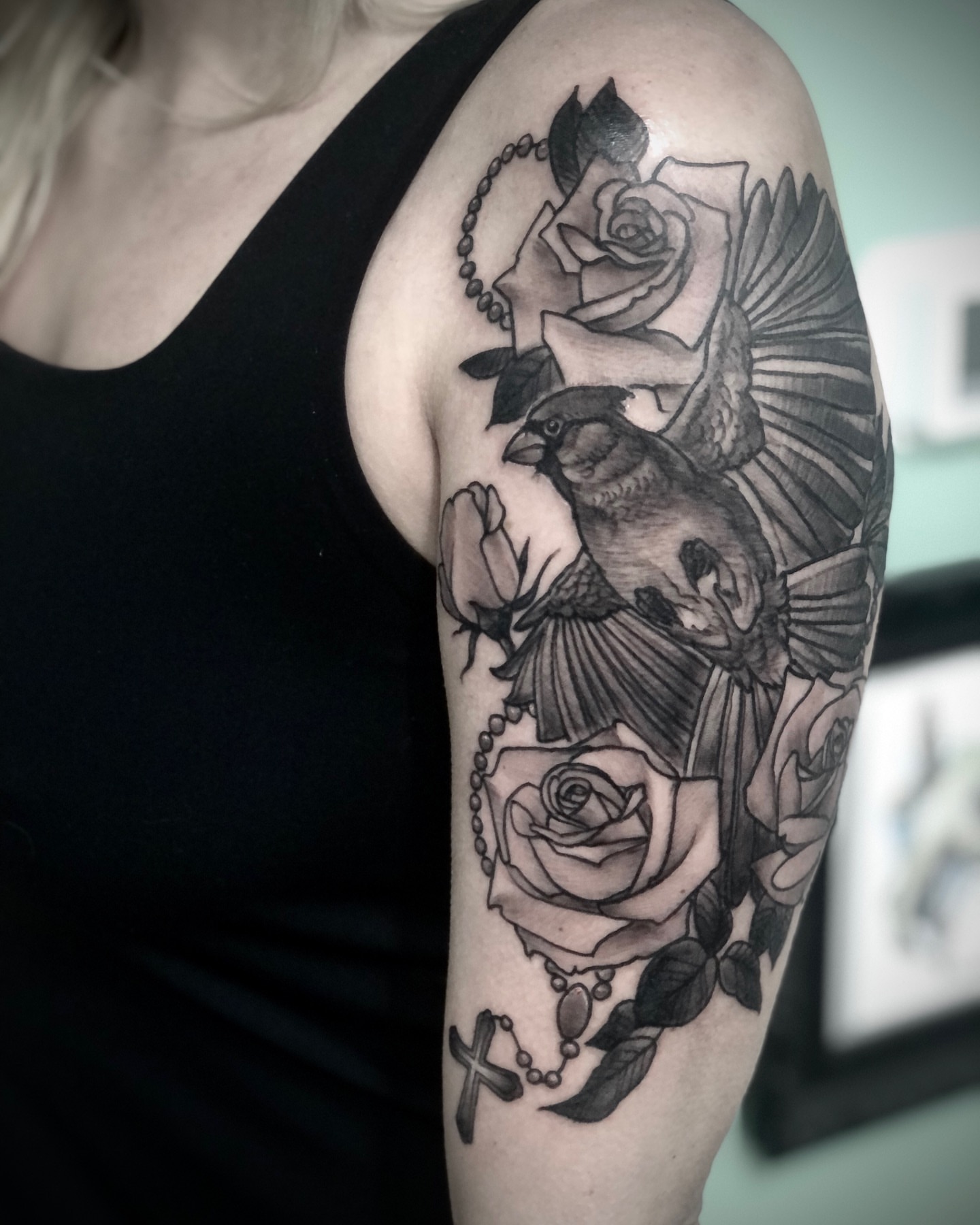 Bird and roses realism tattoo on the upper arm by Alec Bauer