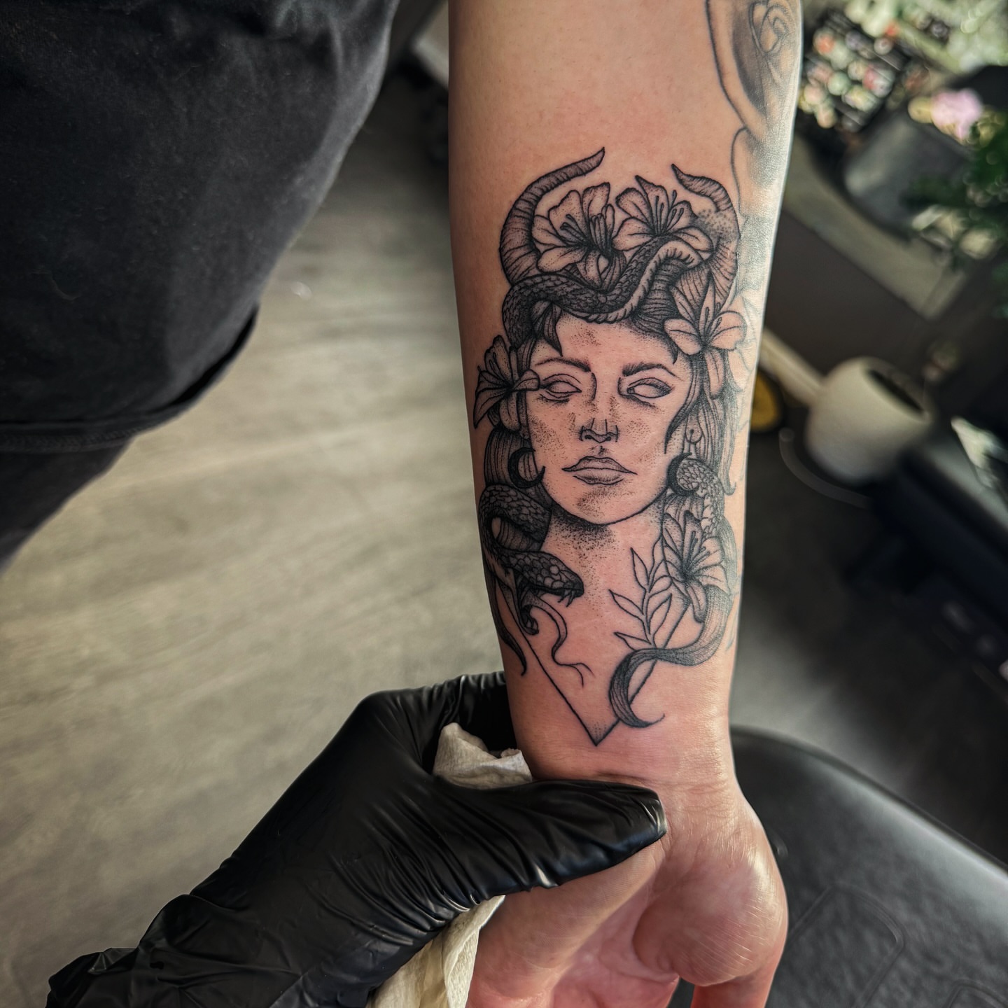 Woman's face with snakes and flowers dotwork tattoo on the forearm by @inkspirationtattoo_co