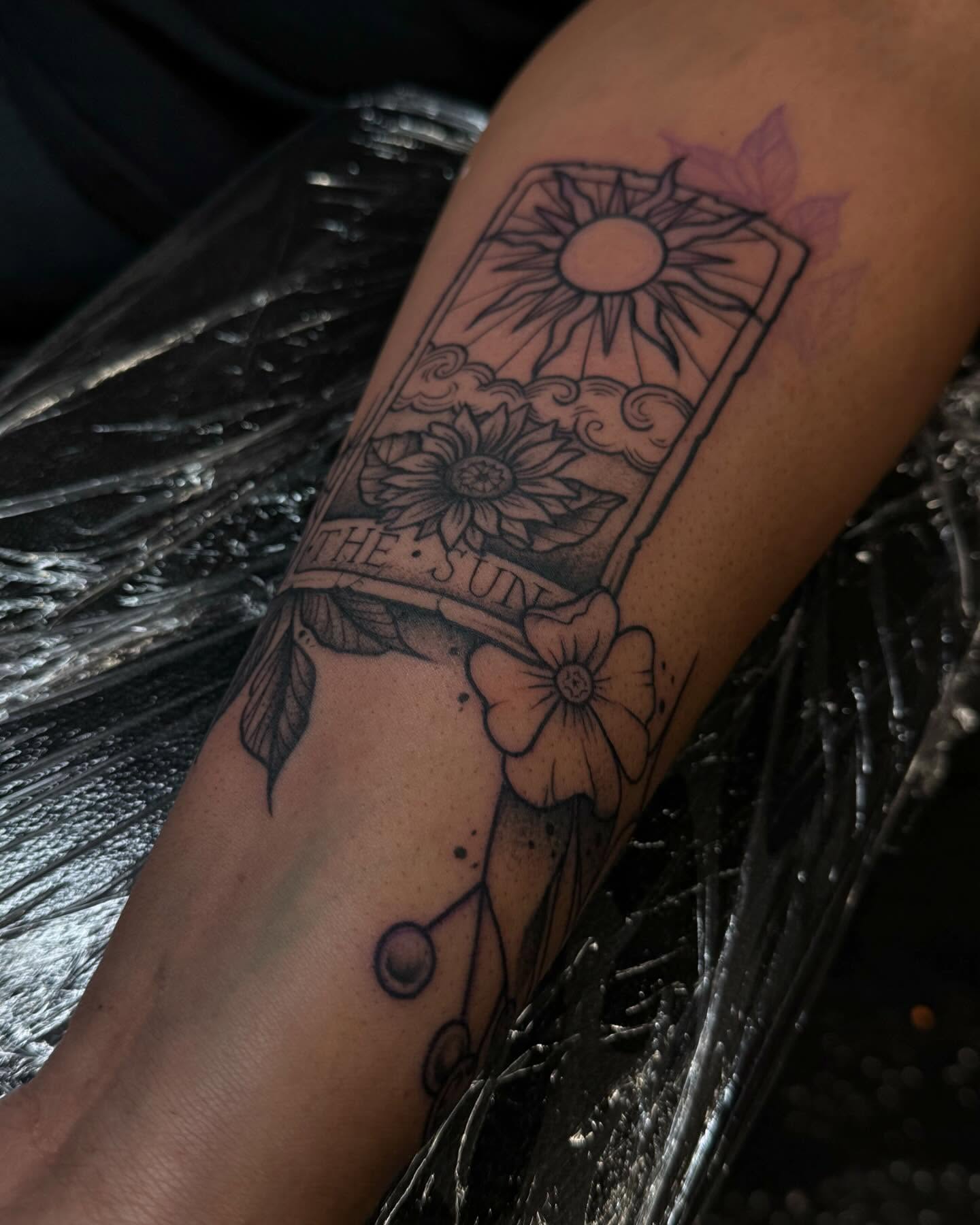 The sun tarot card black and grey tattoo on the forearm by Gabby Finearts