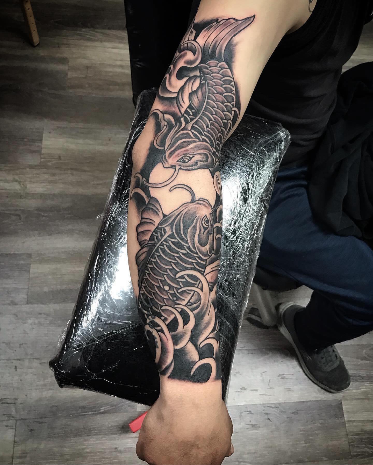 Koi fish black and grey tattoo on the forearm by Tonii Florrez