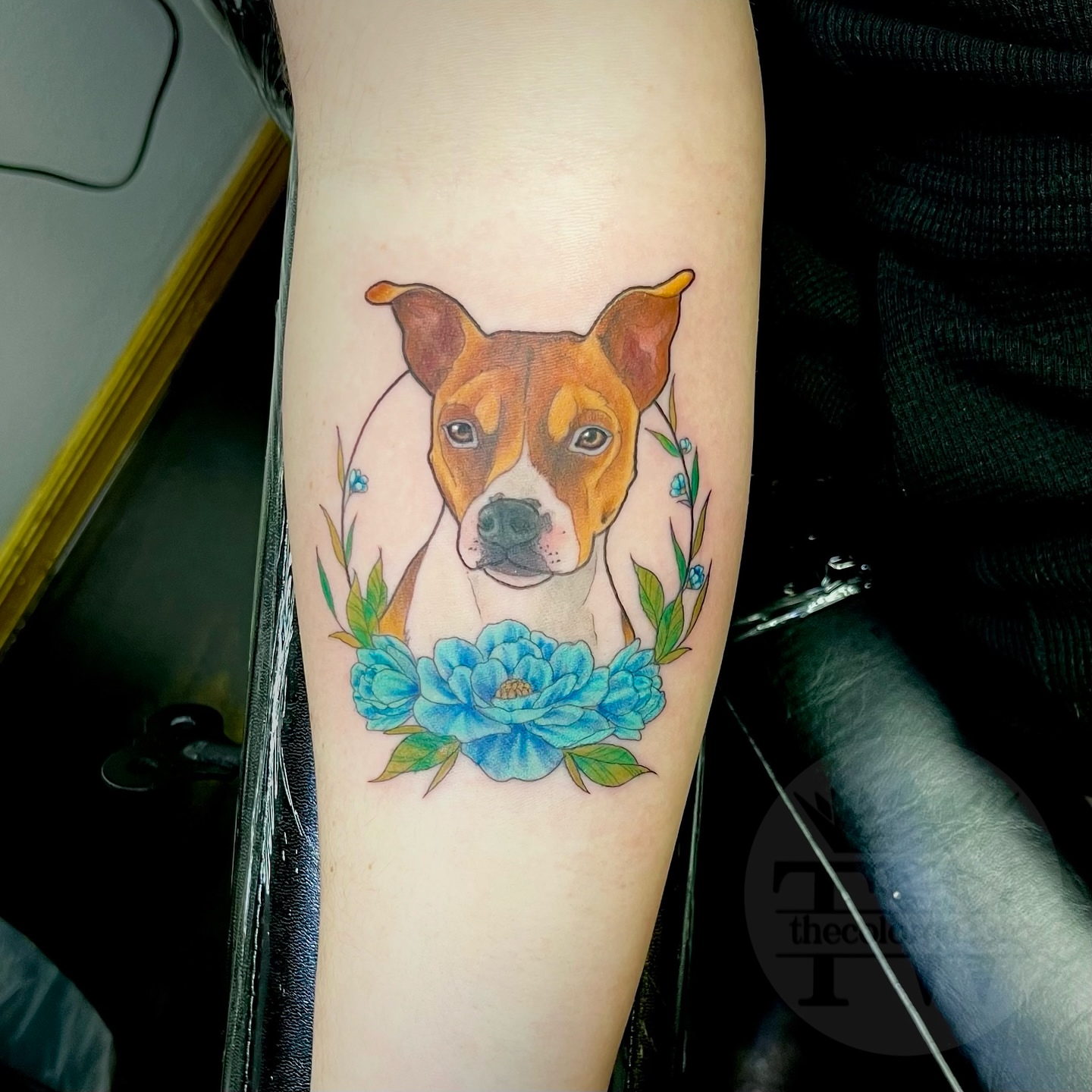 Dog with flowers realism tattoo on the forearm by Taylor Tha Color Queen