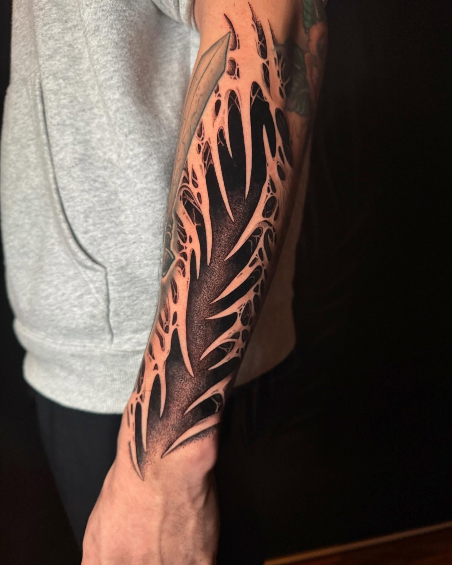 Feather geometric tattoo on the forearm by Dylan Orbock, Berkeley, California