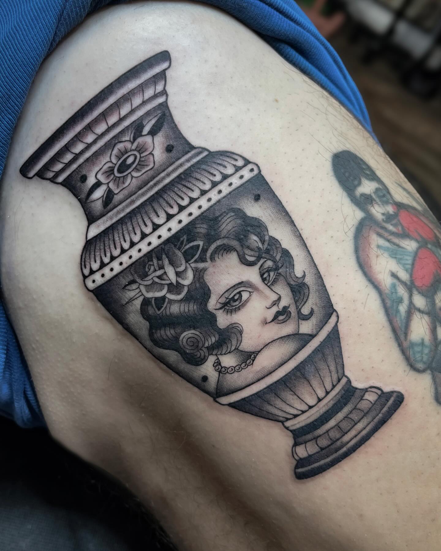 Woman in urn American traditional tattoo on the thigh by Kelsi Steffensen