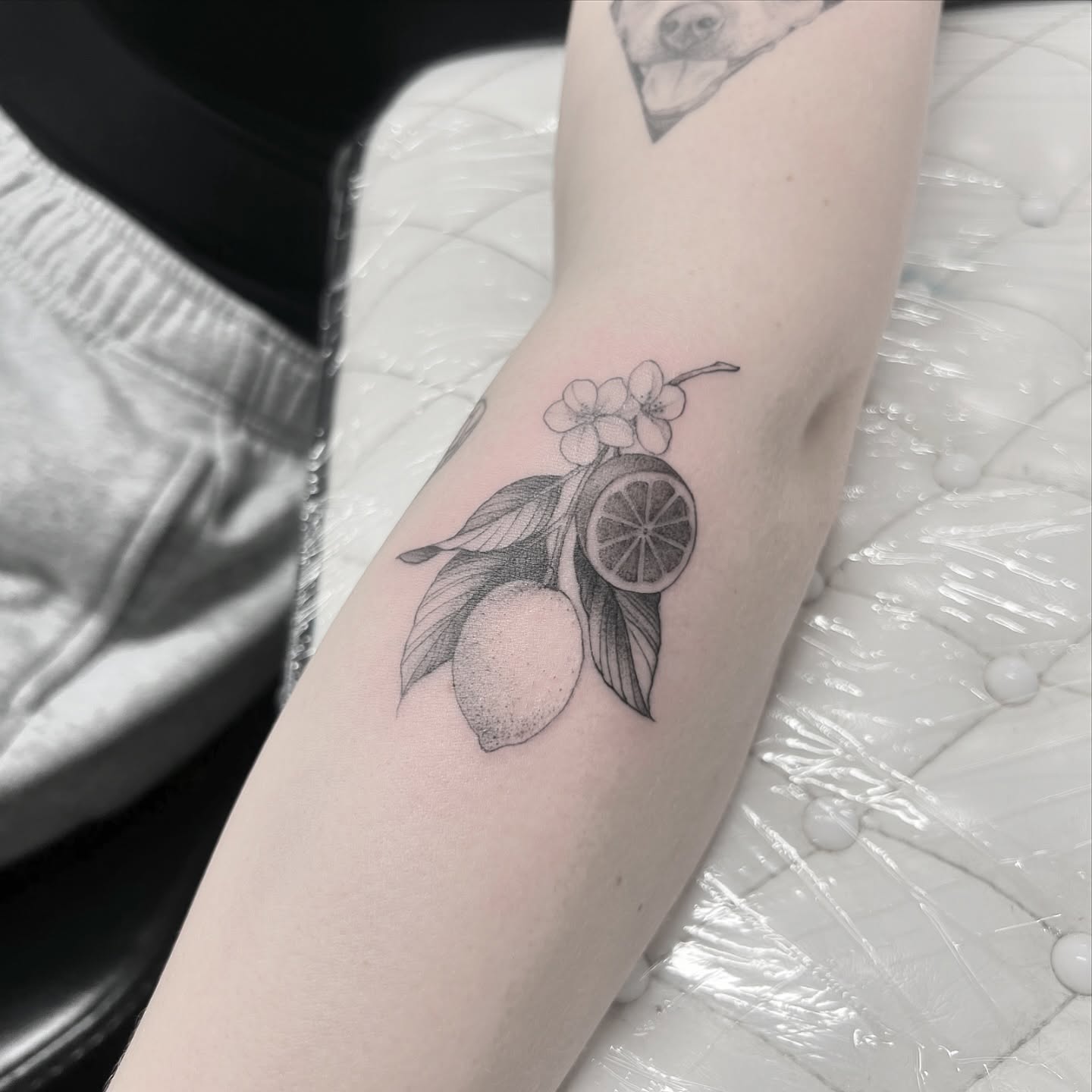 Lemon and flowers realism tattoo on the forearm by Chelsea Speirs
