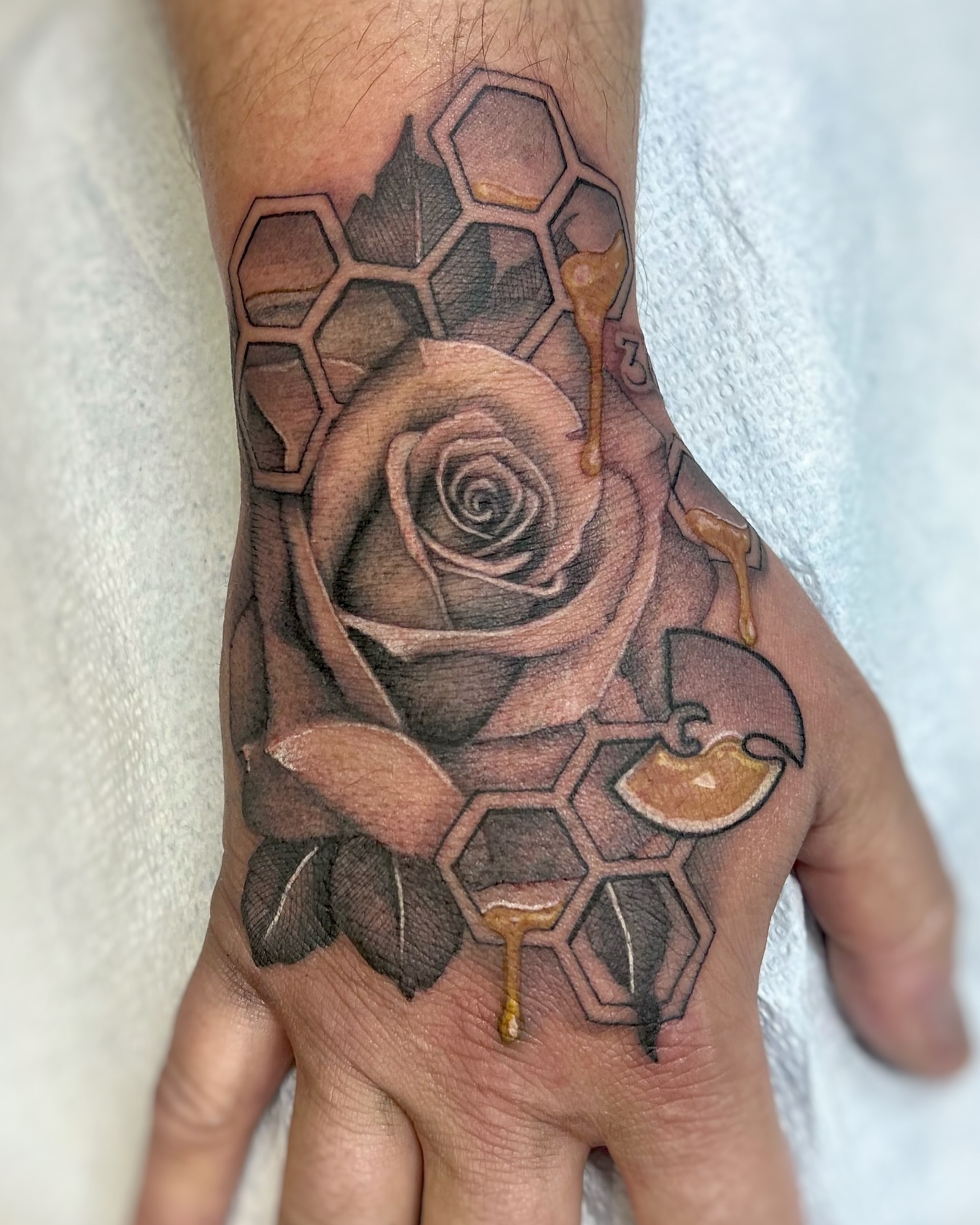 Rose and honeycomb realism tattoo on the hand by sam cedar geller 🐝