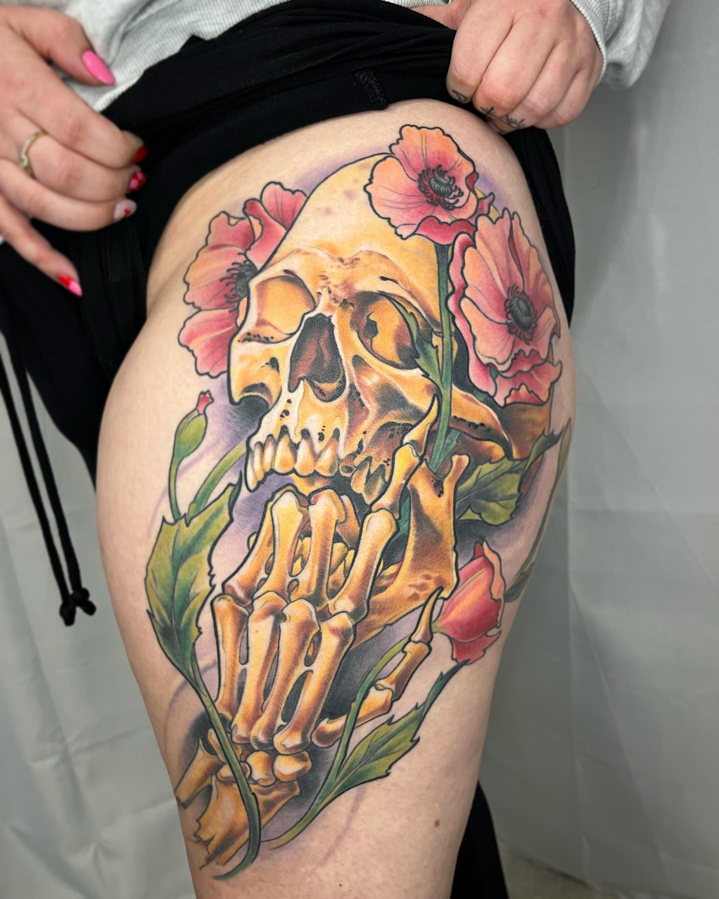 Skull with poppies realism tattoo on the thigh by biggstattoos