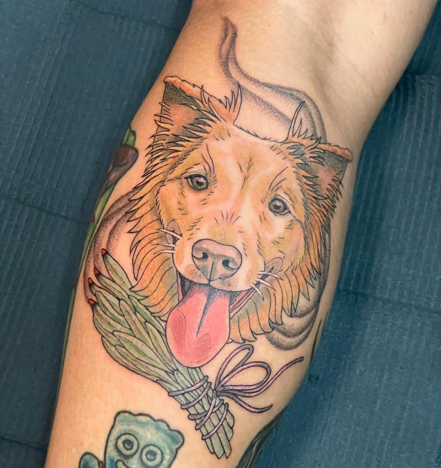 Dog with laurel wreath realism tattoo on the forearm by Candence Smith