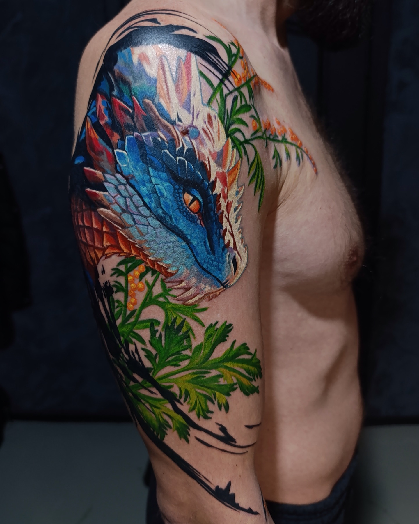 Dragon and foliage new school tattoo on the upper arm by Vladimir Lutaev