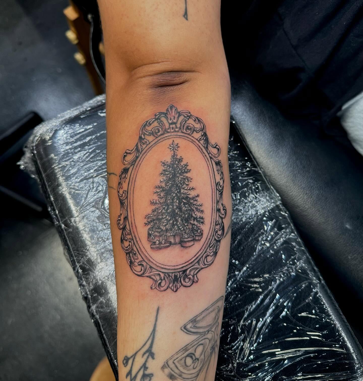Christmas tree black and grey tattoo on the forearm by Kenzie🖤