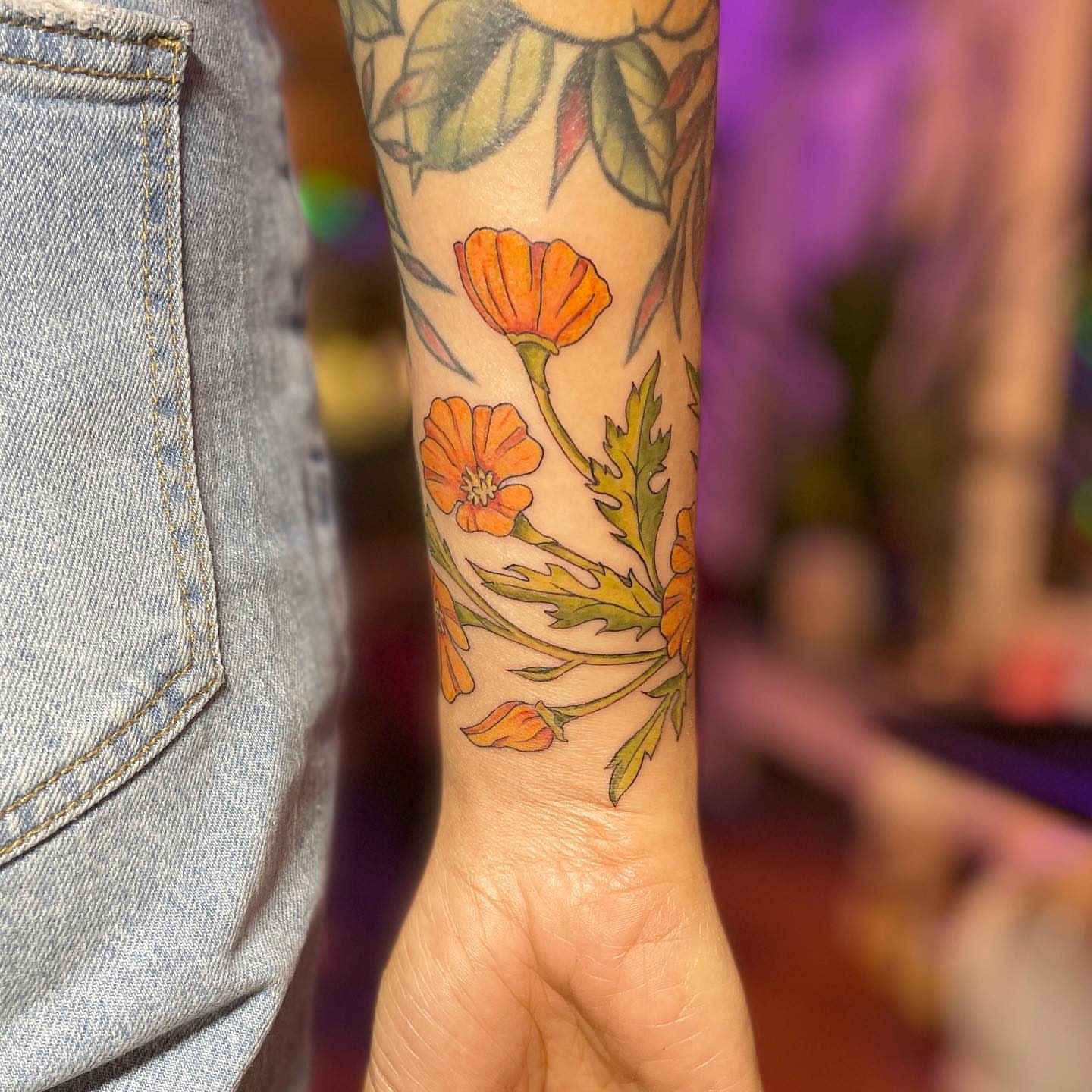 Orange flowers new school tattoo on the forearm by Reba Slate