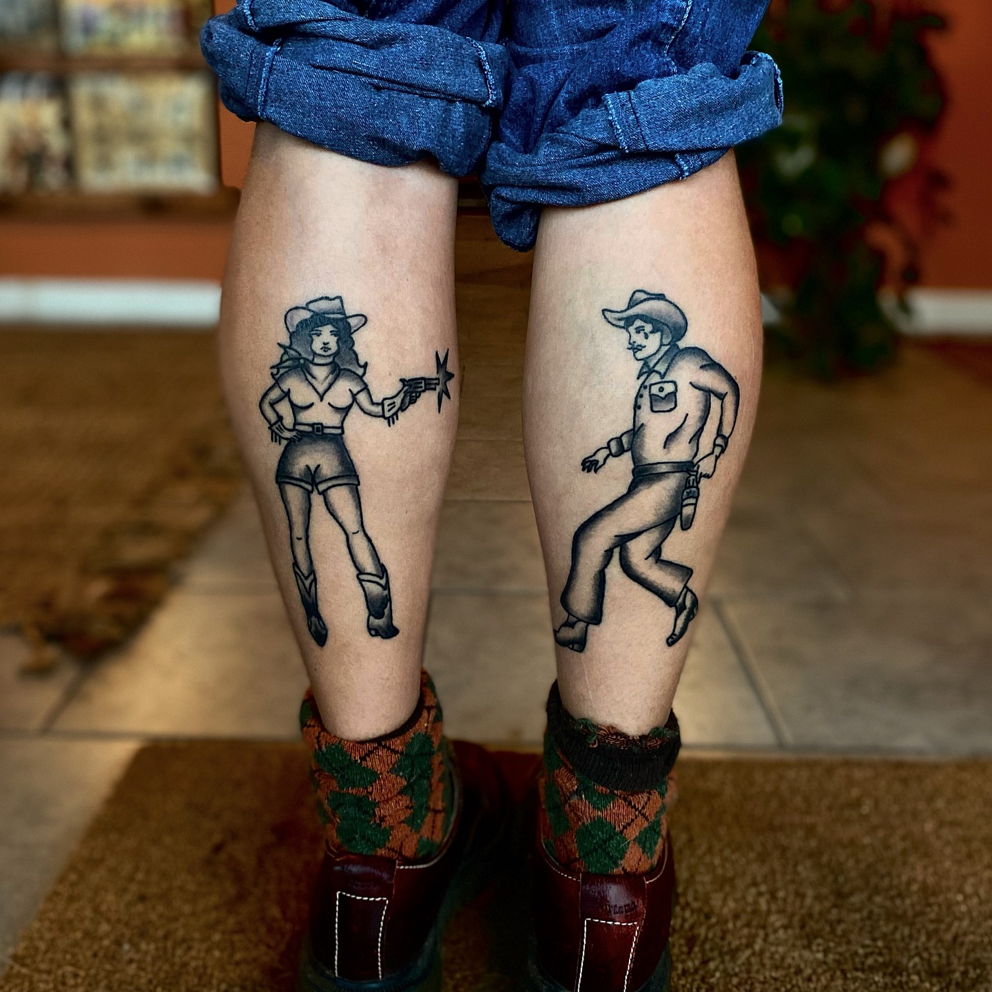 Cowgirl and cowboy black and grey tattoo on the leg by Myka King