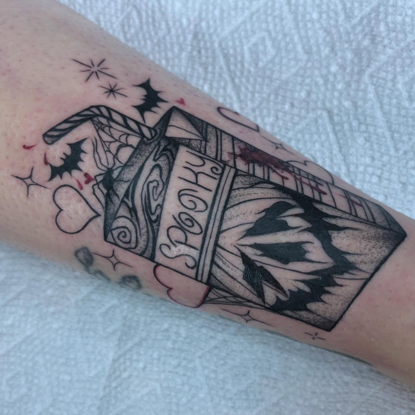 Casket with floral arrangement black and grey tattoo on the forearm by Ivanna